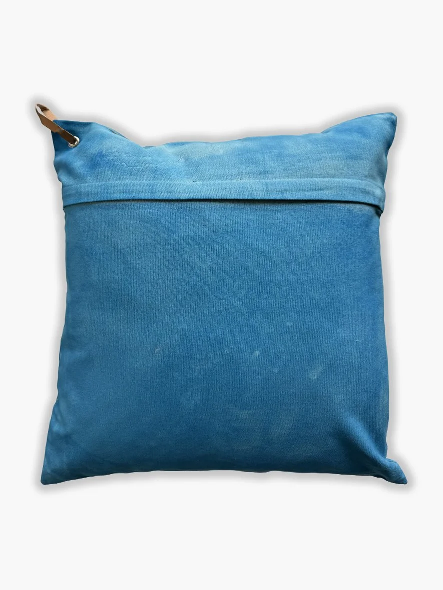 Back view of a cushion with an artistic washed background in sky blue.