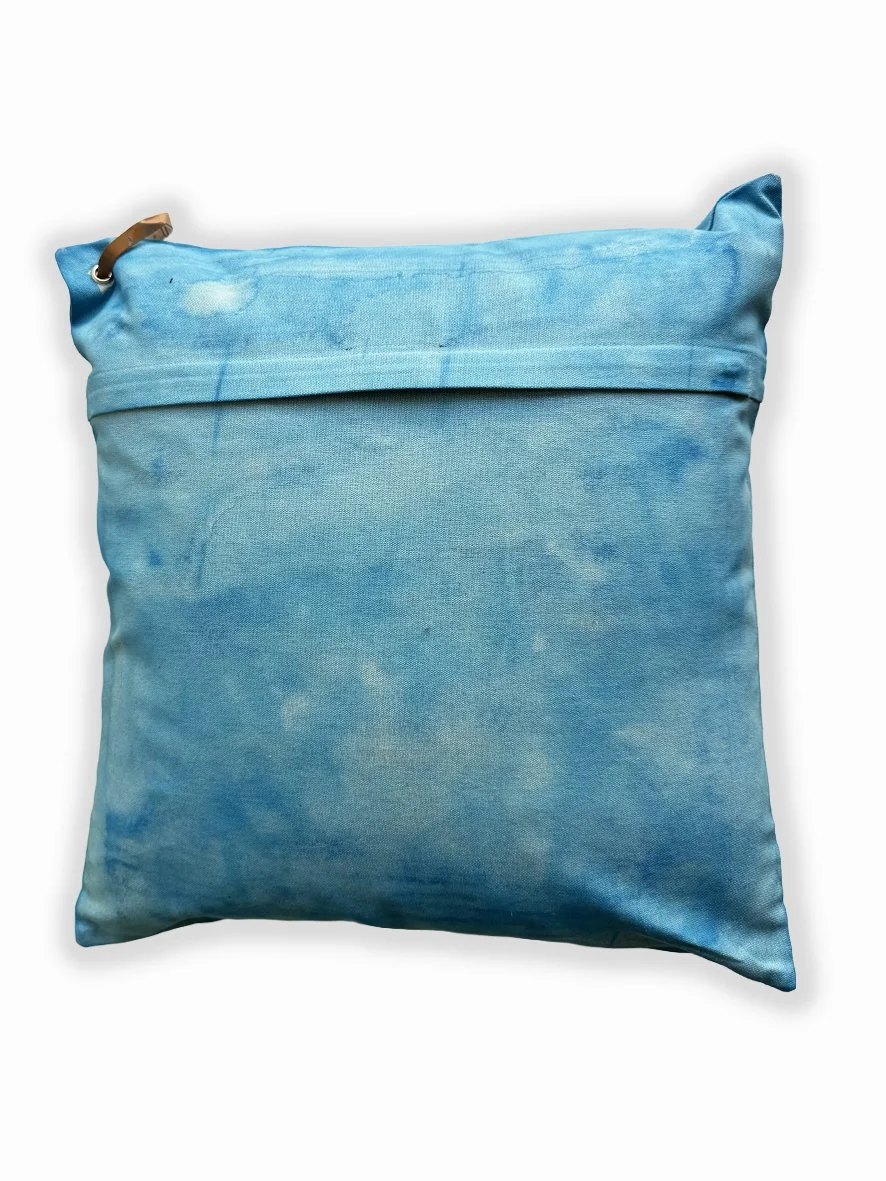 Back view of a cushion with an artistic washed background in sky blue.
