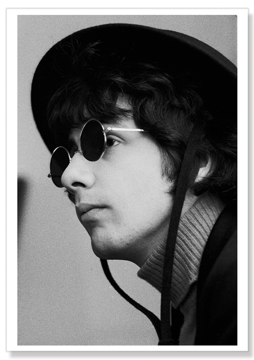 Black and white close-up portrait of Cat Stevens wearing a large black Spanish style hat and dark rounded sunglasses.  Print shows borders and drop shadow.