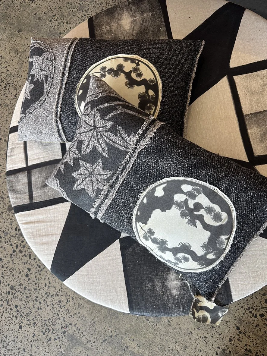 Sakura wool and silk cushions on a monochromatic ottoman.