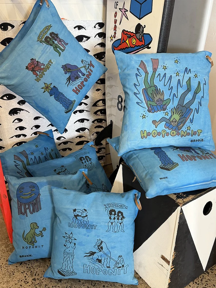 A collection of cushions with sky blue artistic background and images by Brodie Jackson for Hoponit Studio with a skate and surf theme.