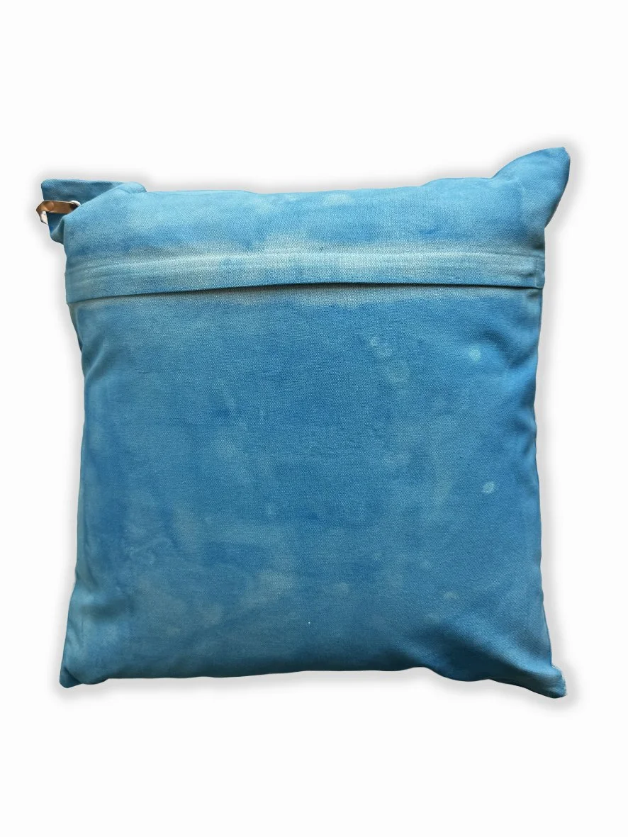 Back view of a cushion with an artistic washed background in sky blue.