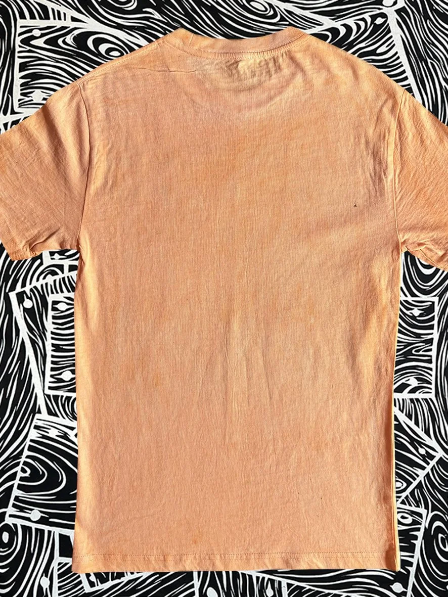 Back view of a treated orange tshirt and with black and white woodgrain fabric behind.