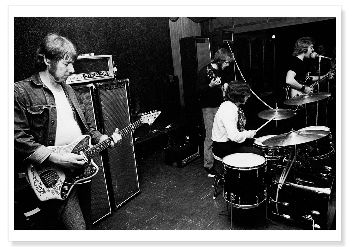 Black and white image of Lobby Loyde playing guitar on stage with Billy Thorpe and the Aztecs.  Print shows borders and drop shadow.