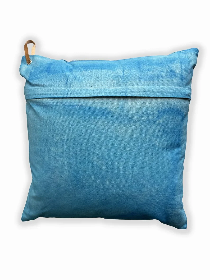 Back view of a cushion with an artistic washed background in sky blue.
