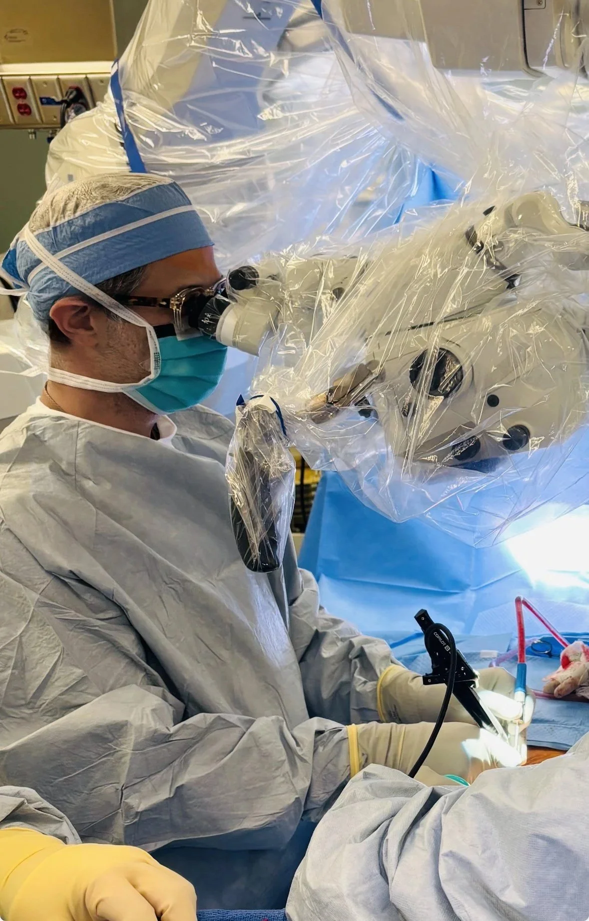 Dr. Robert Ames operating through a surgical microscope
