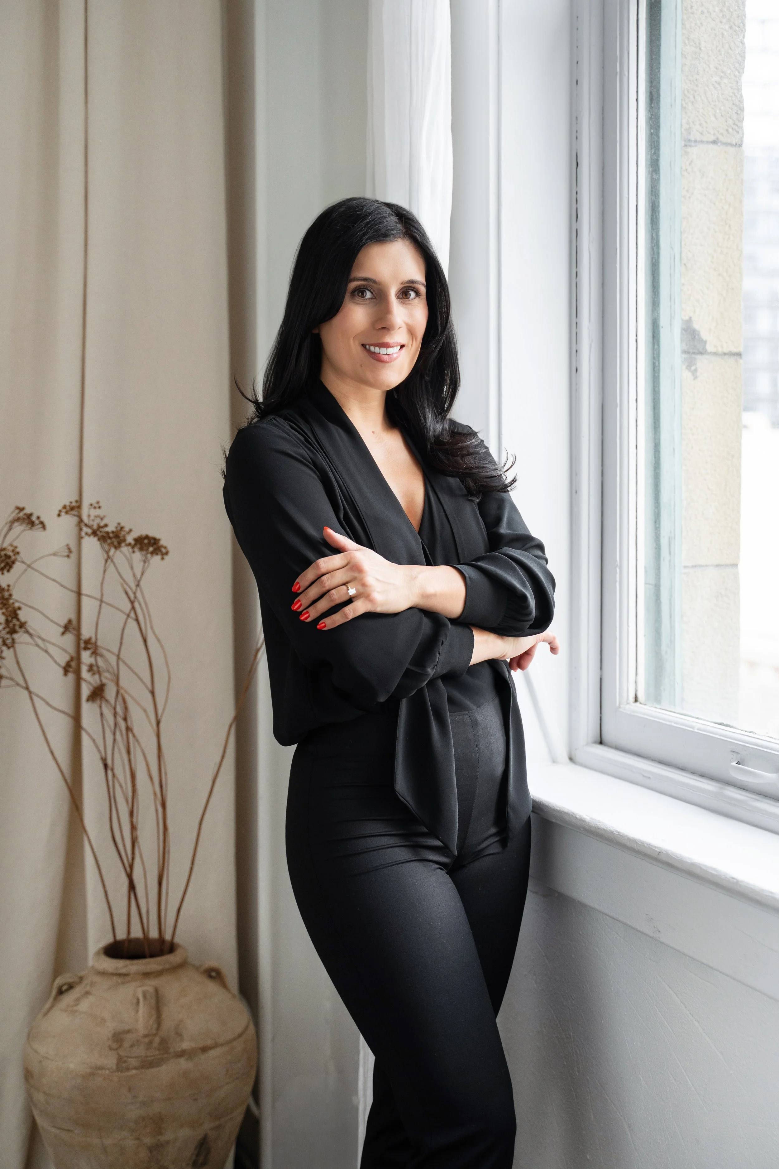 Melissa Caouette smiling beside a window, September 2026 portrait.