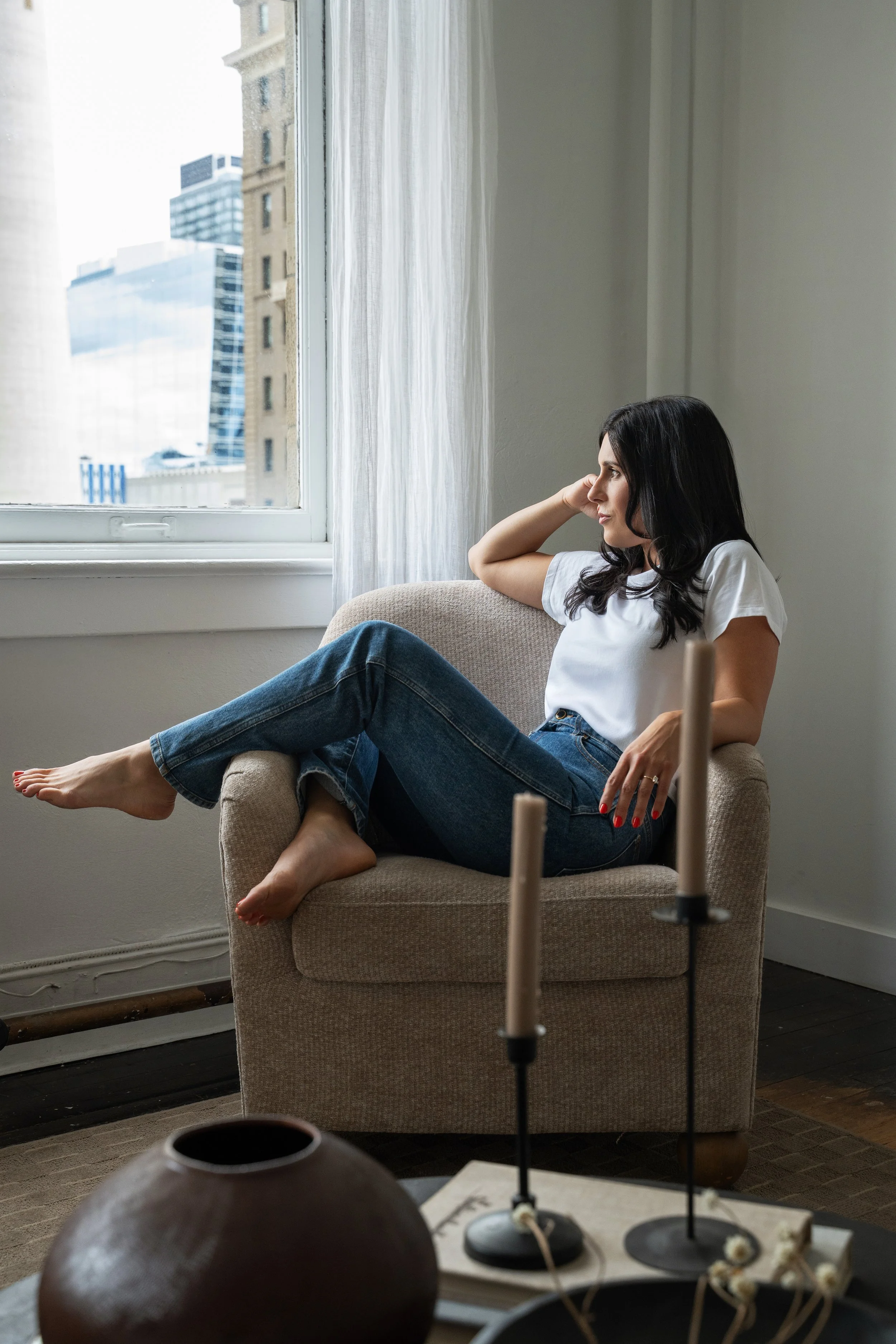 Melissa Caouette seated in an armchair beside a window, September 2026.