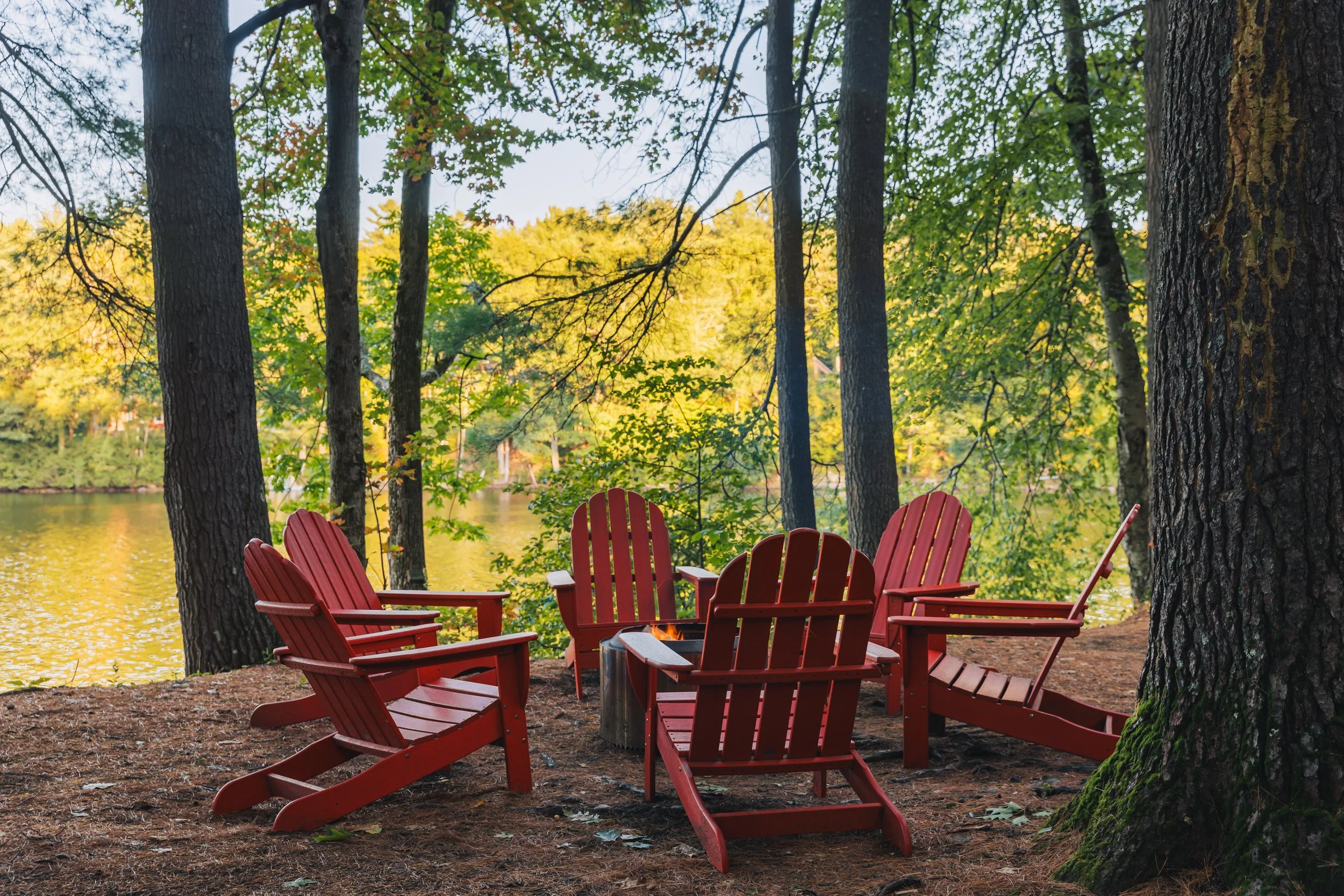 Rest and relax in your Adirondack chairs arranged in a circle around a fire pit in a wooded lakeside setting in the Adirondacks near Saratoga and Lake George.