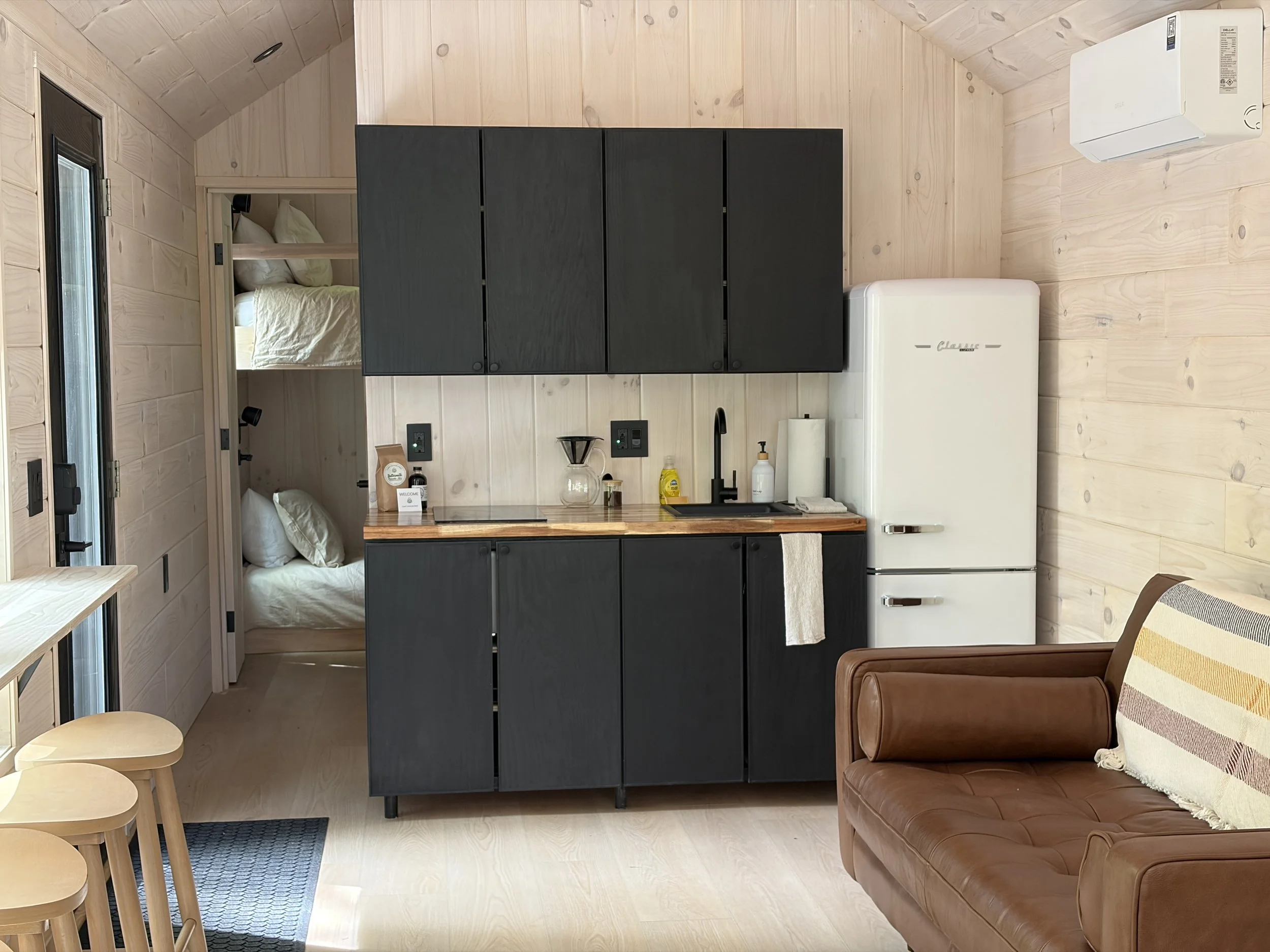 The Walnut and Chestnut cabins have a couch, seating for four, a kitchenette with a tall refrigerator and a bunk room.