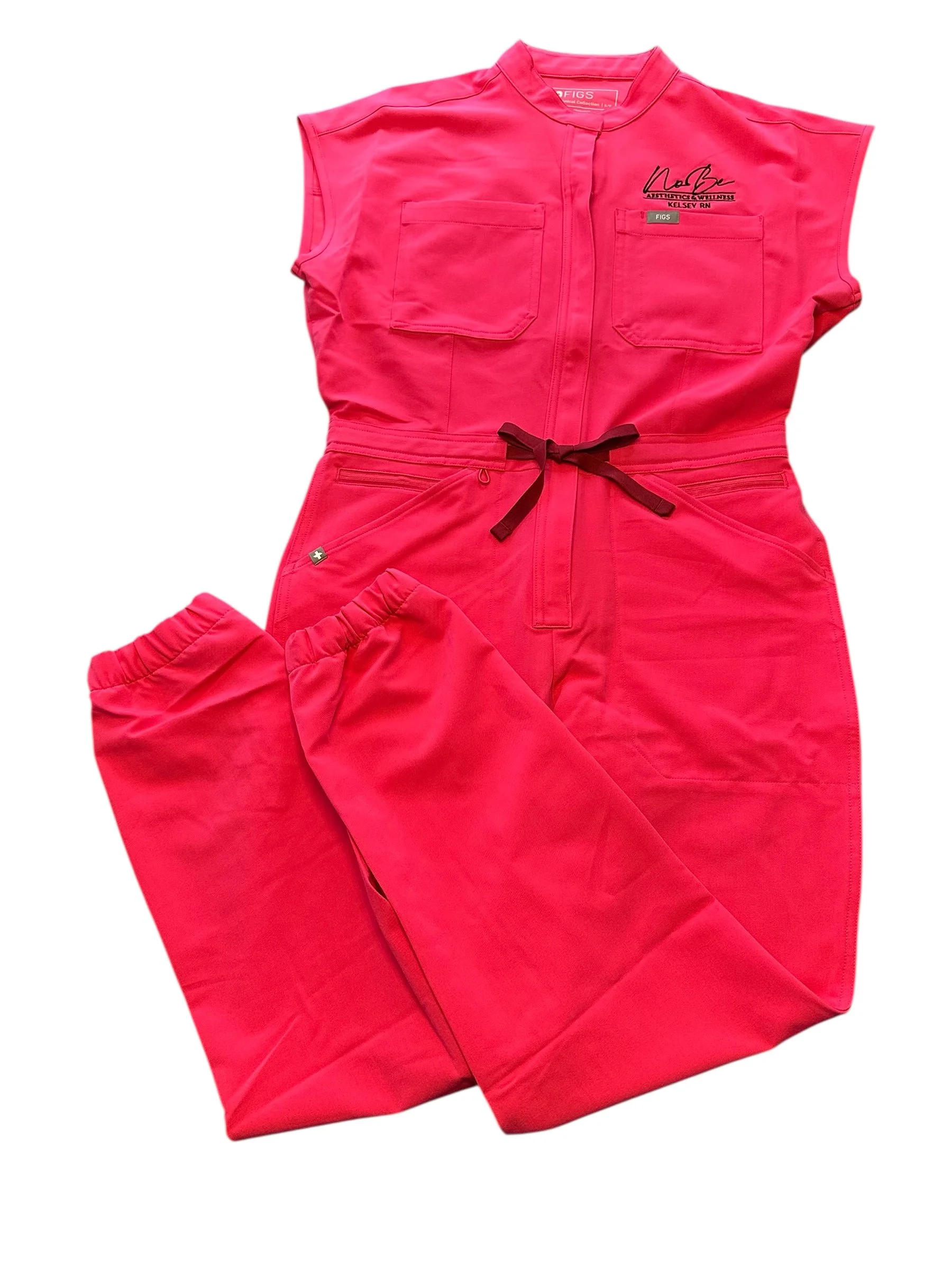 Red medical scrubs with two chest pockets, a black drawstring, and a signature on the top right chest area.