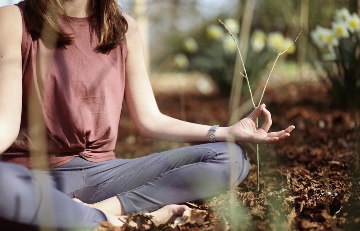 Sam seated in meditation in a peaceful woodland setting