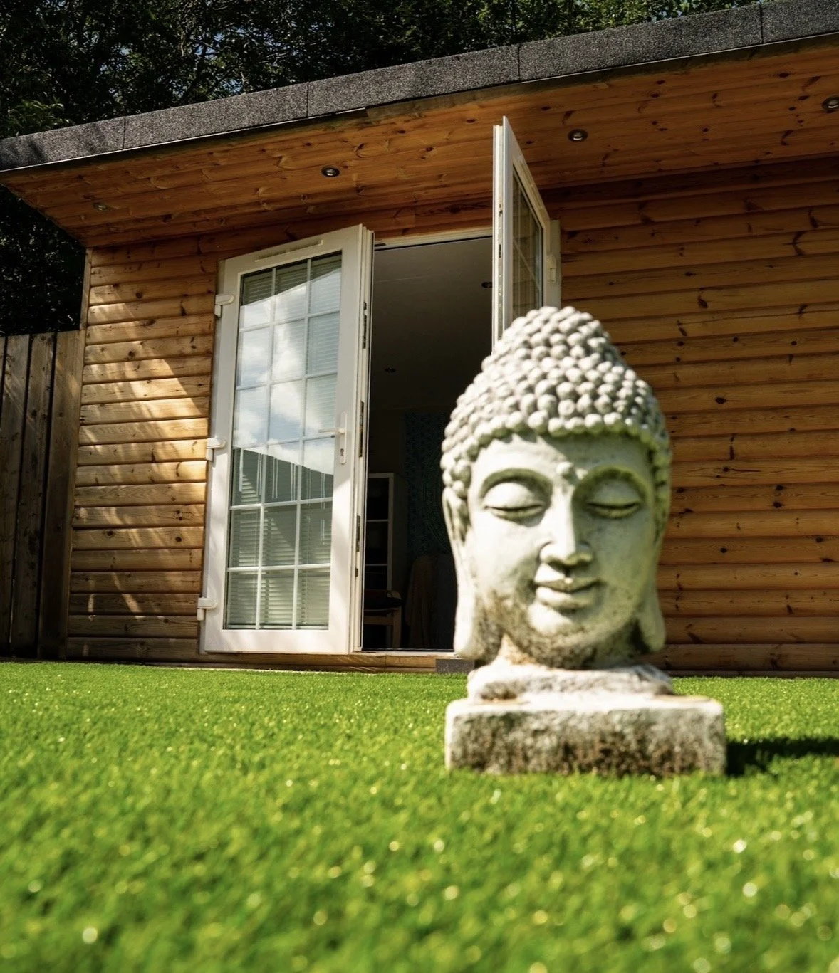 The Wellness Hut with a peaceful Buddha statue in the garden