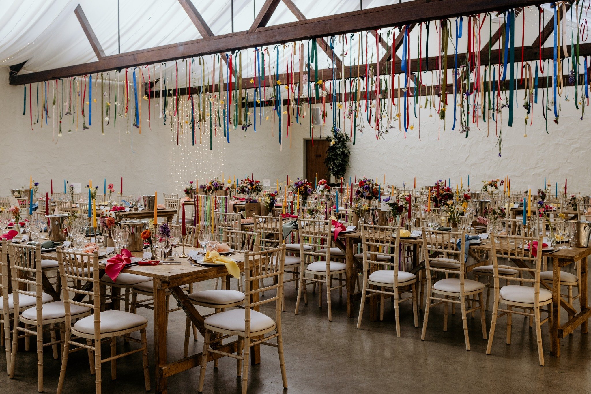 Let's embrace colourful weddings! 🌷🦋🌼🌈

We absolutely LOVED the colourful vibe from Amy &amp; Robbie's wedding in April.

They added multicolored ribbons to their ceremony chairs, and carried on this theme with colourful ribbons and florals drape
