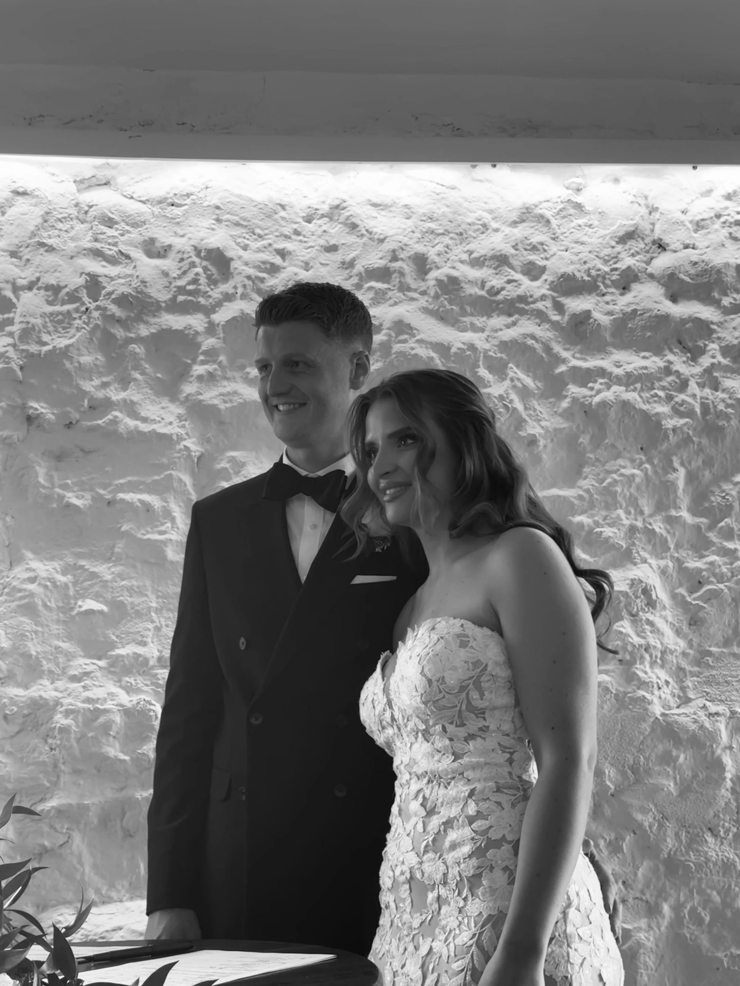 Newlyweds Maddie and Harry smiling during their wedding reception inside the rustic brick barn at Bachilton Barn wedding venue in Perthshire, Scotland.