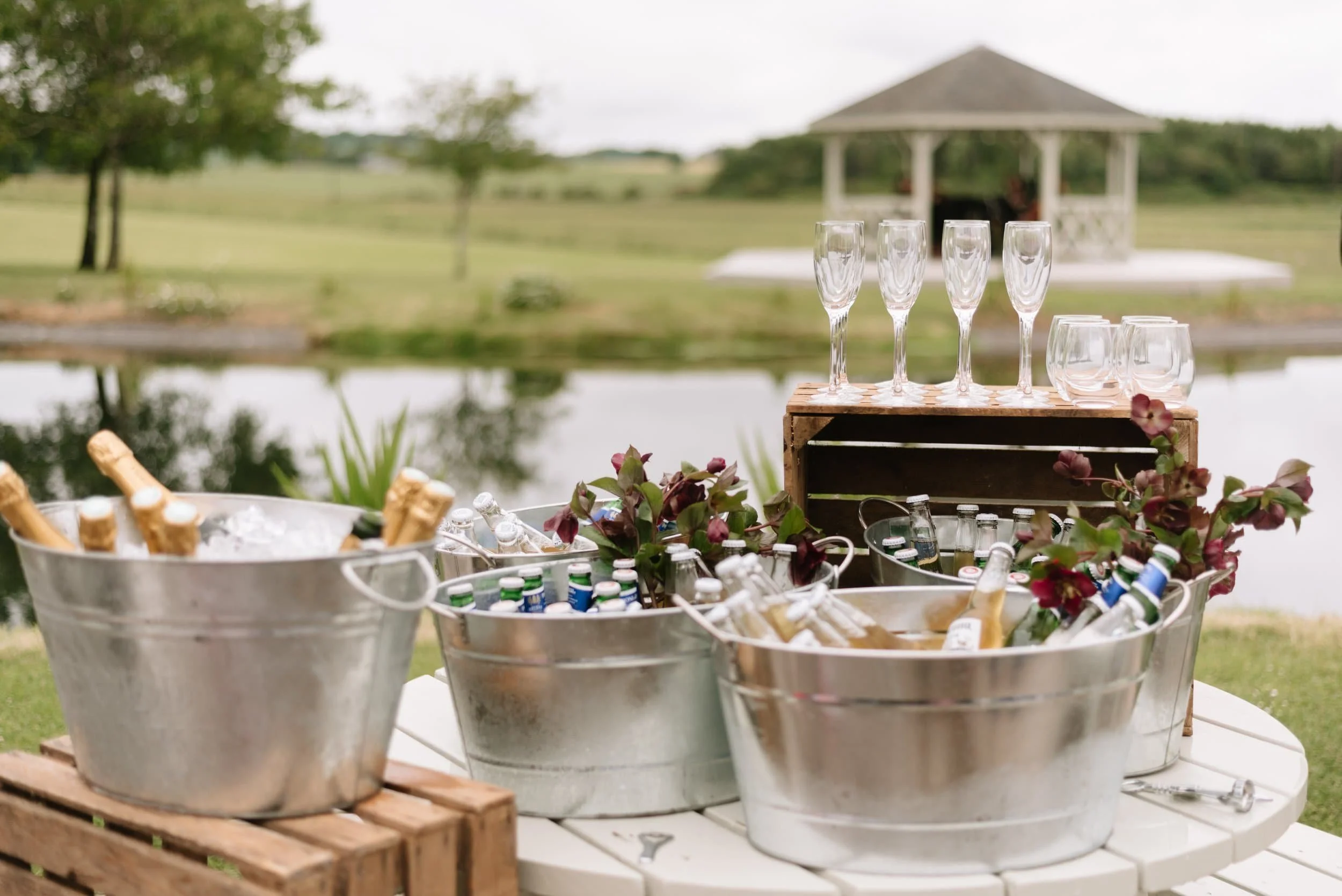 Buckets of prosecco and beer with ice, appear on a table in front of Bachilton Barn's gazebo.