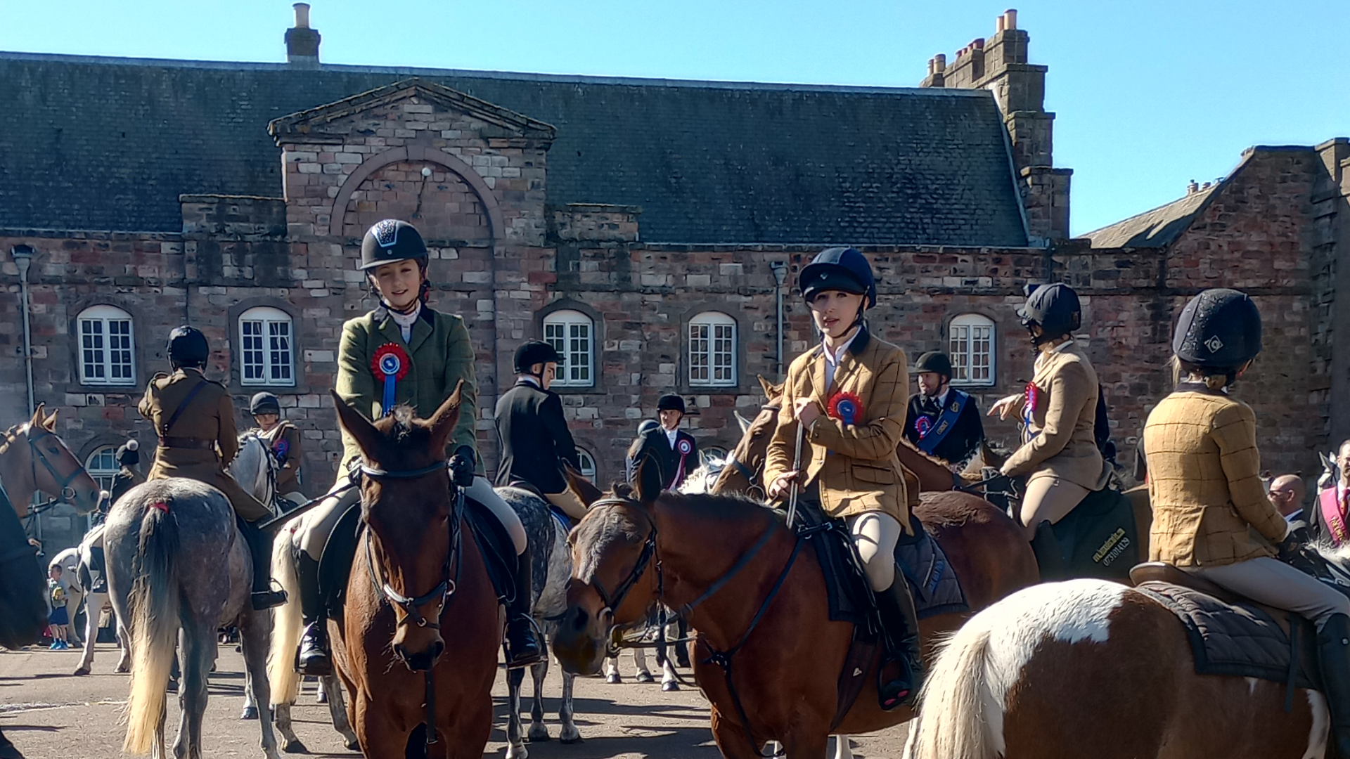 Horses with riders gather in front of the Clock Block - an old stone building in the Berwick Barracks