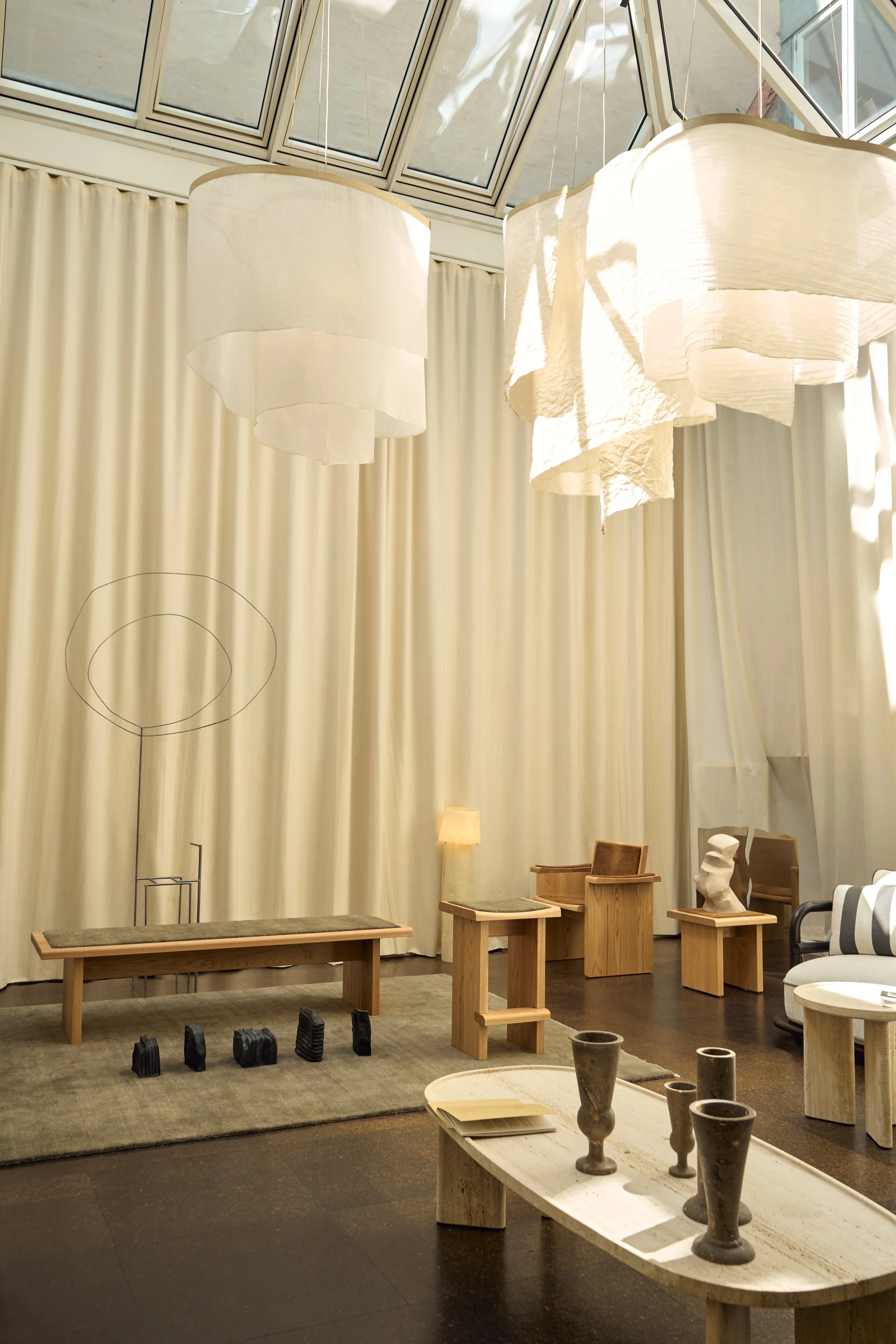 Curated 'Enter the Salon' exhibition by Openhouse Magazine at The Conary, Copenhagen, featuring ethereal Altostratus fabric pendants by Ladies and Gentleman Studio and minimalist oak furniture.  