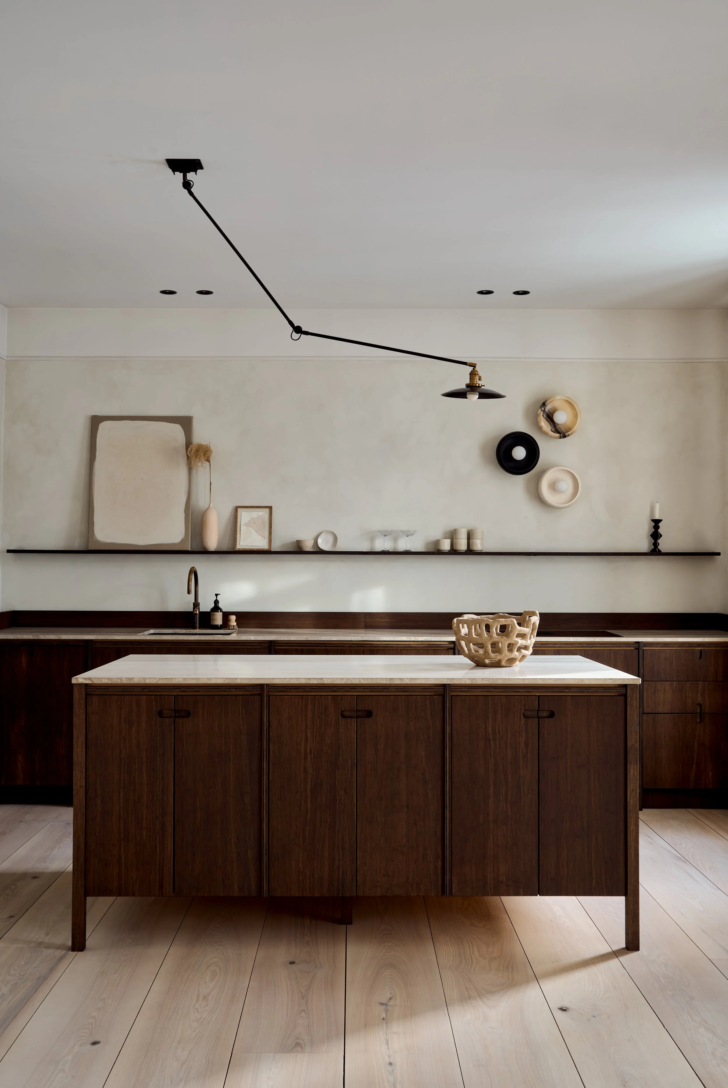 Ask og Eng minimalist bamboo kitchen in the Drammen House featuring lime wash walls and black pendant lighting. 
