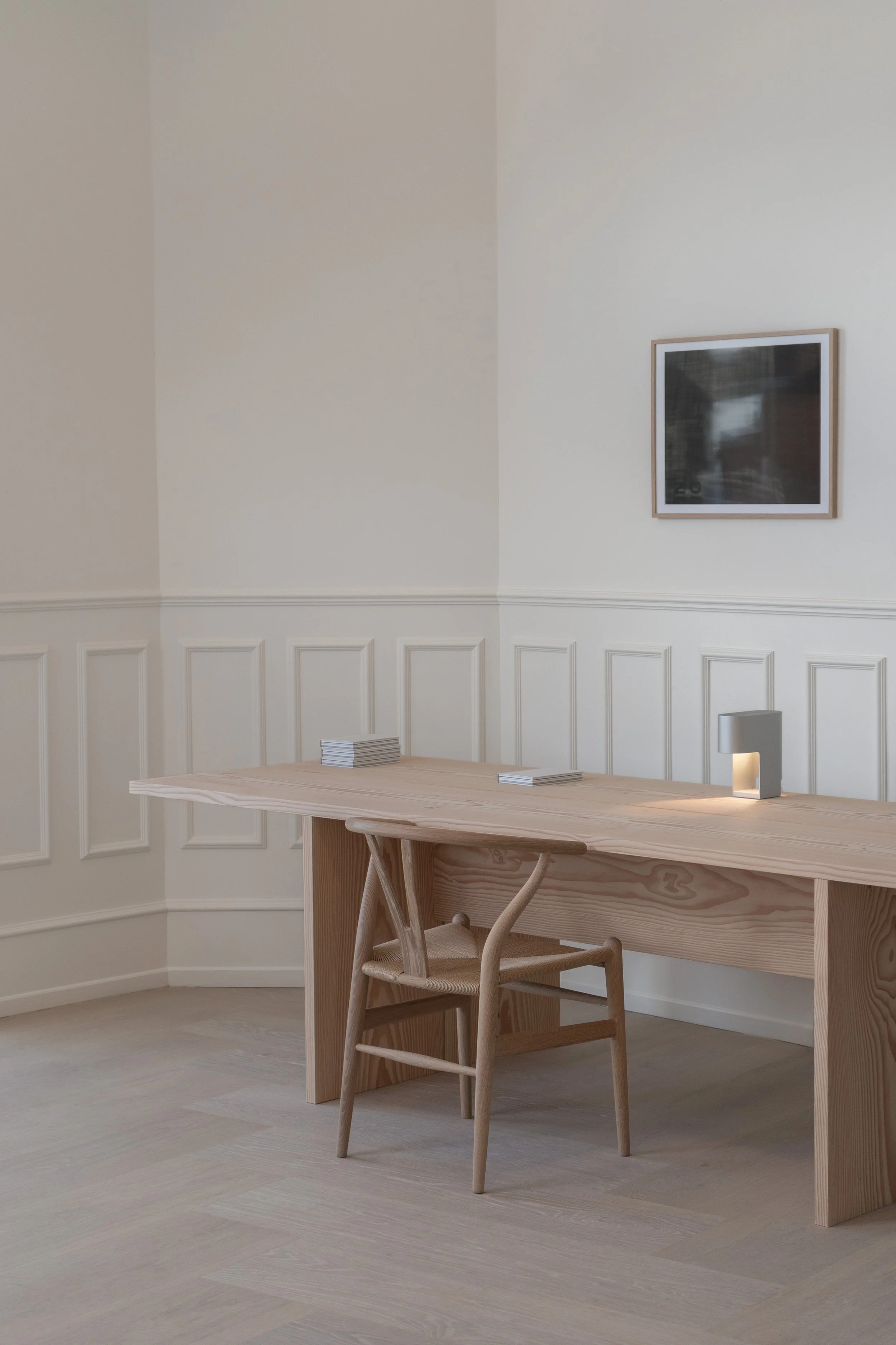 Dinesen and John Pawson collaboration featuring a Douglas Fir dining table and CH24 Wishbone Chair in a minimalist workspace. 
