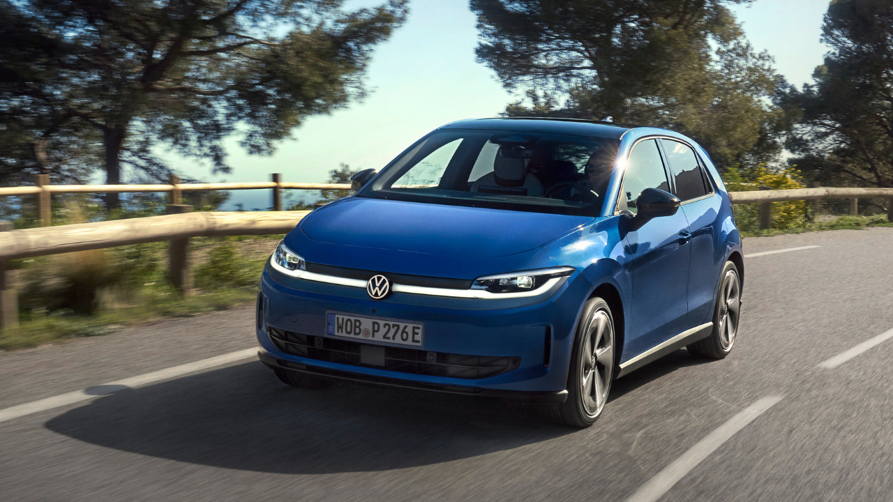 Blue Volkswagen ID. Polo driving on sunny coastal road with trees, highlighting the id polo ev performance.