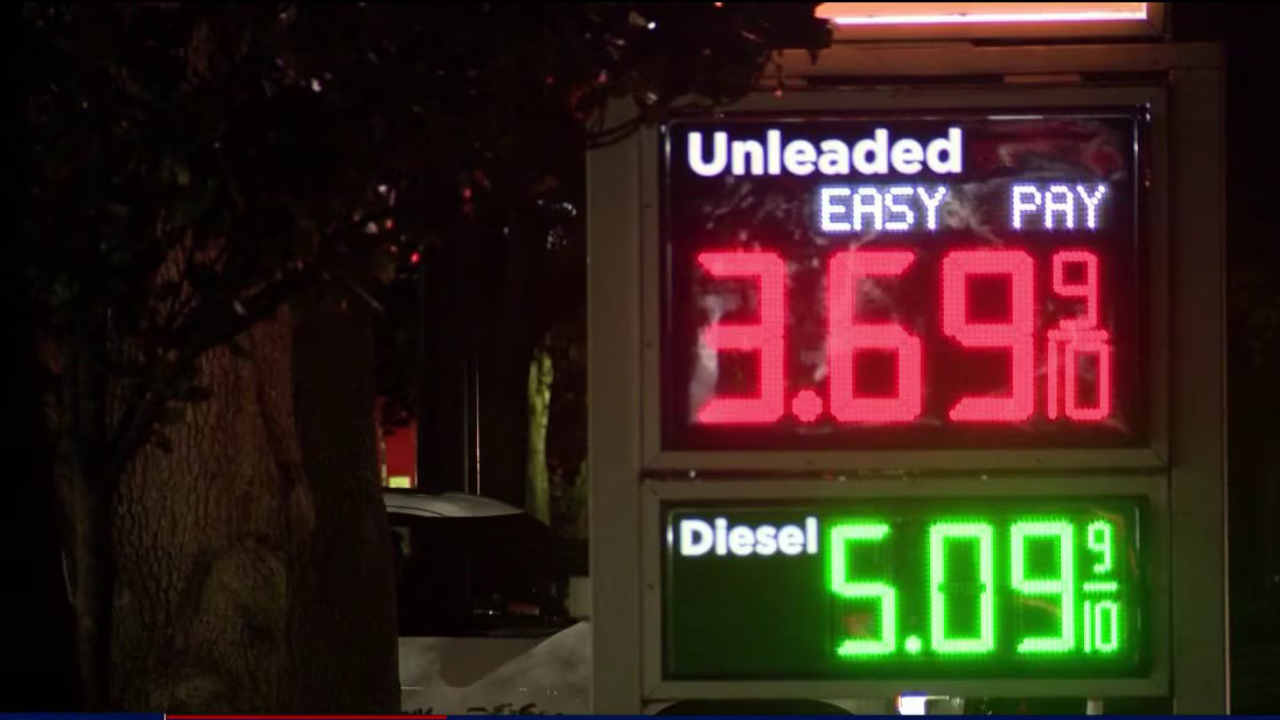 Gas station sign at night showing high unleaded and diesel prices, highlighting the pain of rising fuel costs.
