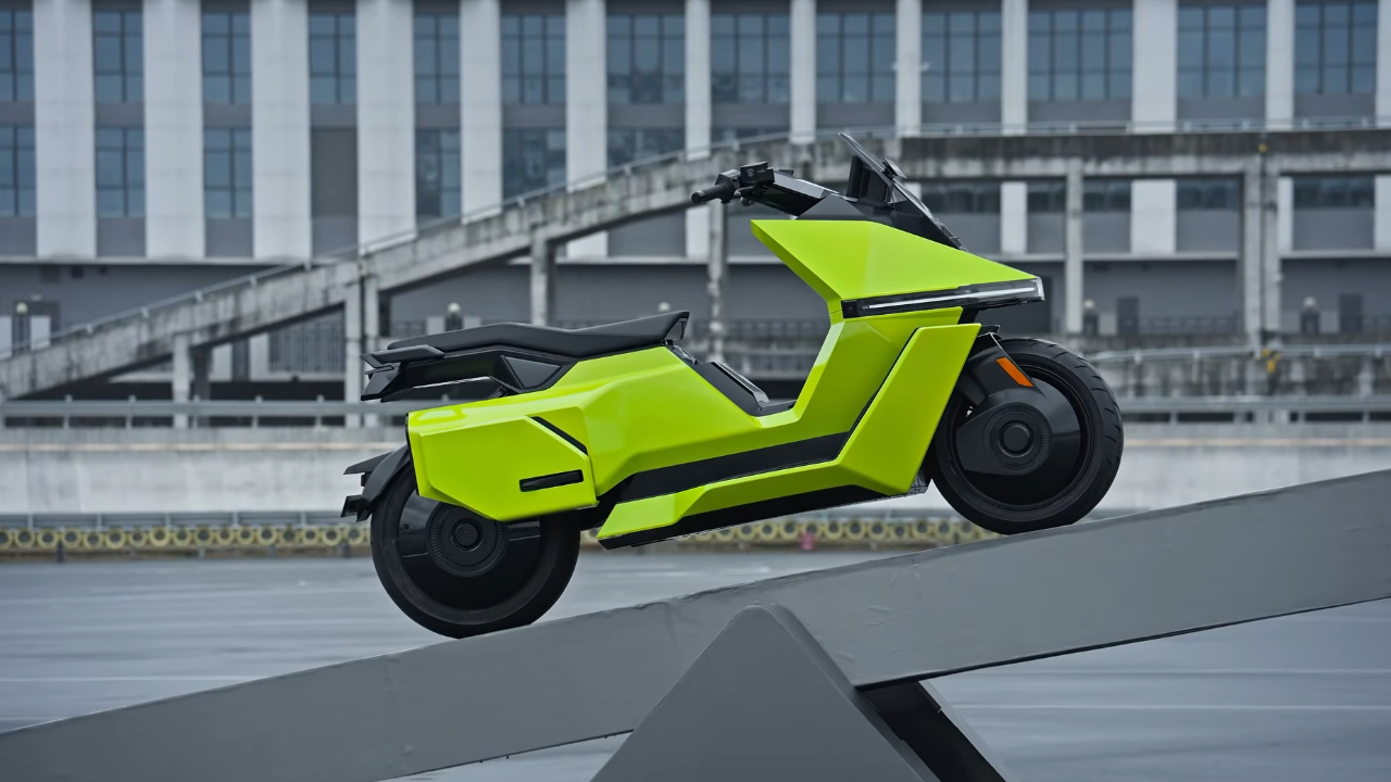 Neon green Omoway OMO X electric scooter balances on a metal ramp outside. Future of urban micromobility.
