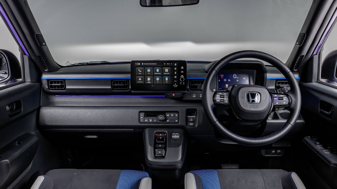 Rendering of a Honda Super-N electric interior with blue ambient lighting and a digital dashboard in a studio.