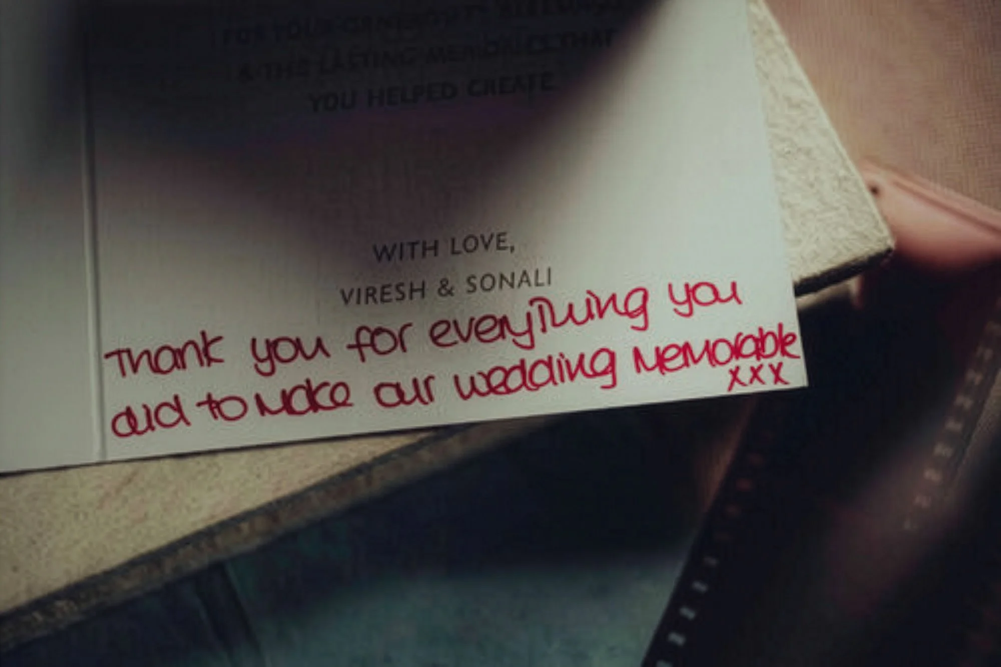 A close-up image of a handwritten thank you note with pink ink on white paper, expressing gratitude for a wedding.