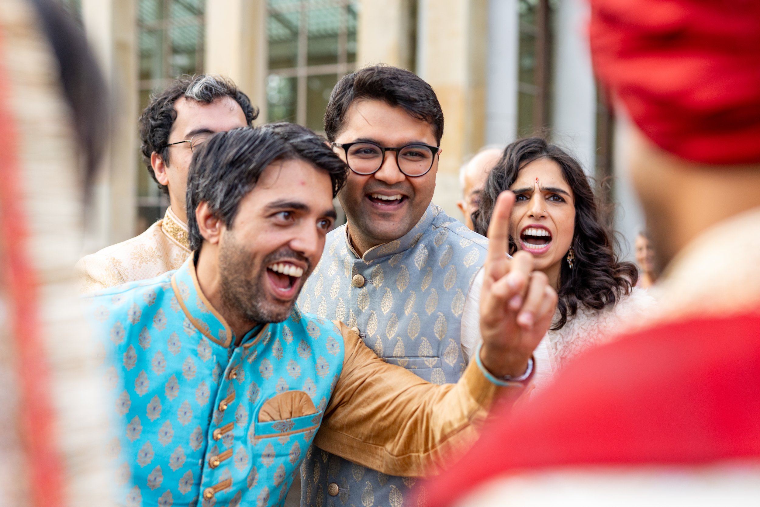 A group of excited people in traditional Indian attire, engaged in a heated discussion or argument during a social event or celebration.