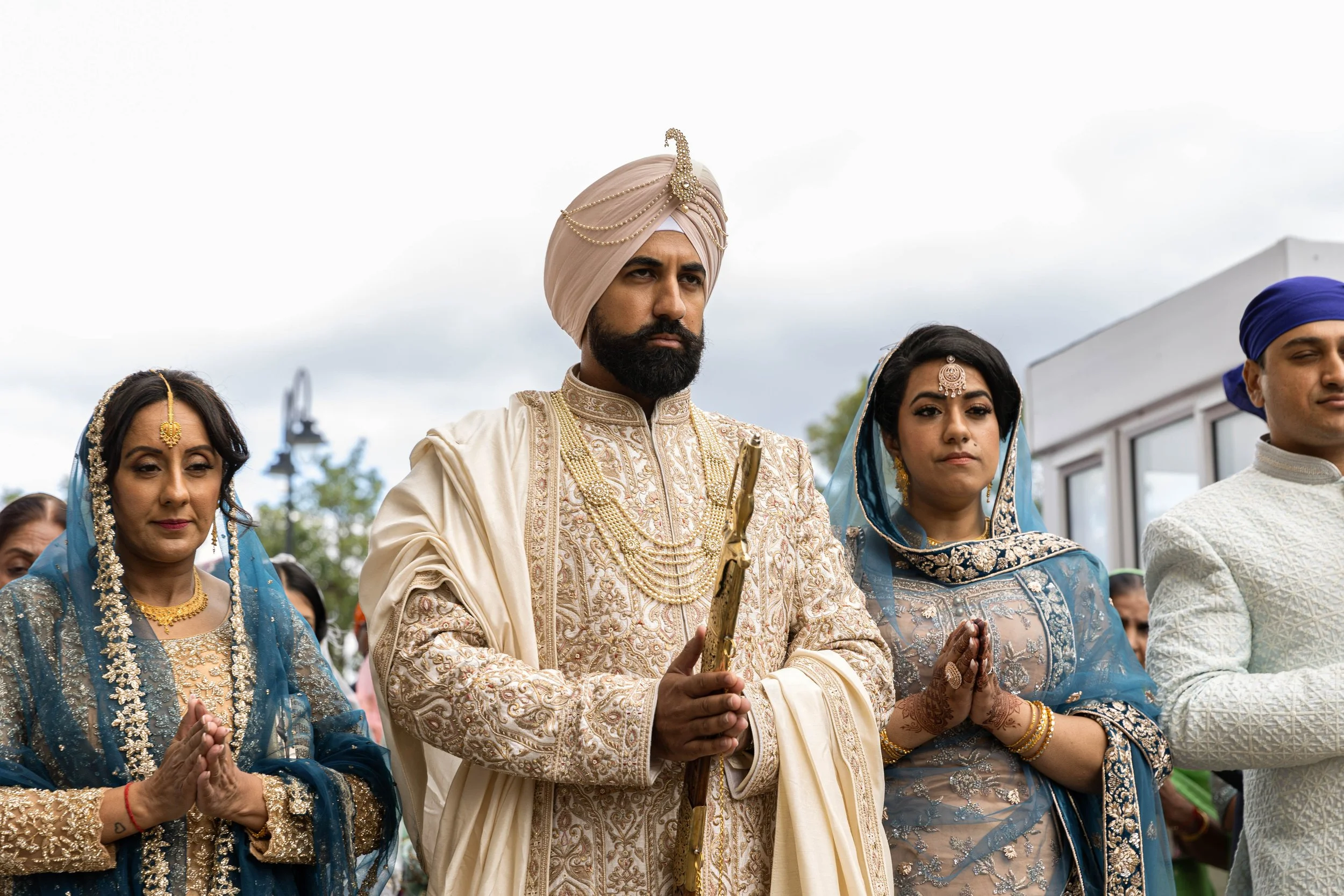 Indian wedding ceremony with bride, groom, and family dressed in traditional attire.