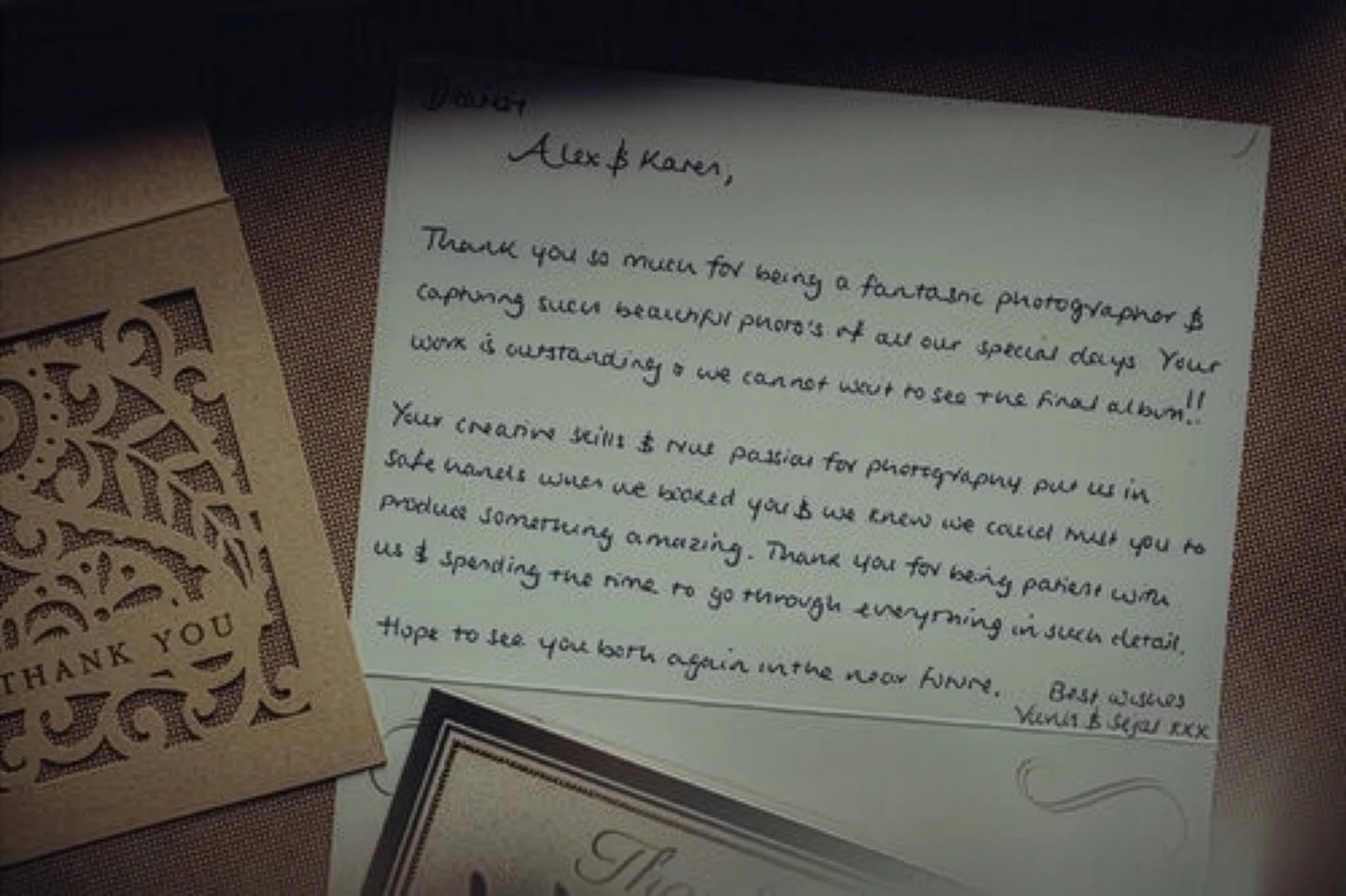 A handwritten thank you note and a decorative thank you card on a textured surface.