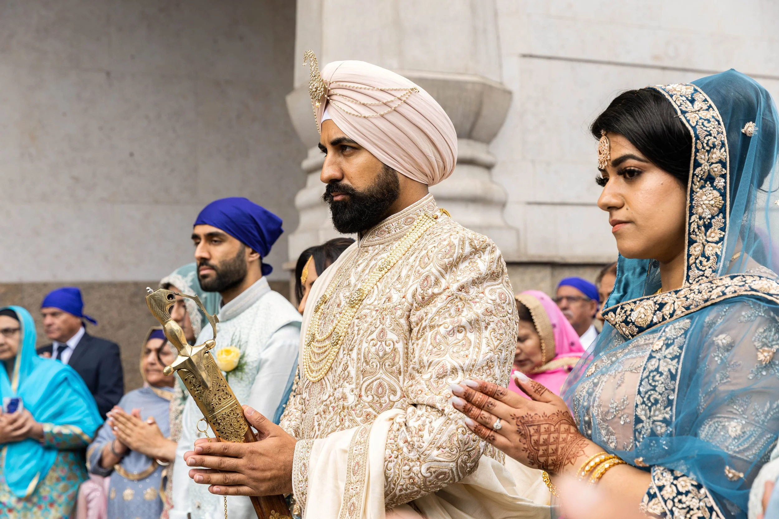 Indian wedding ceremony with bride and groom in traditional attire, surrounded by family and friends.