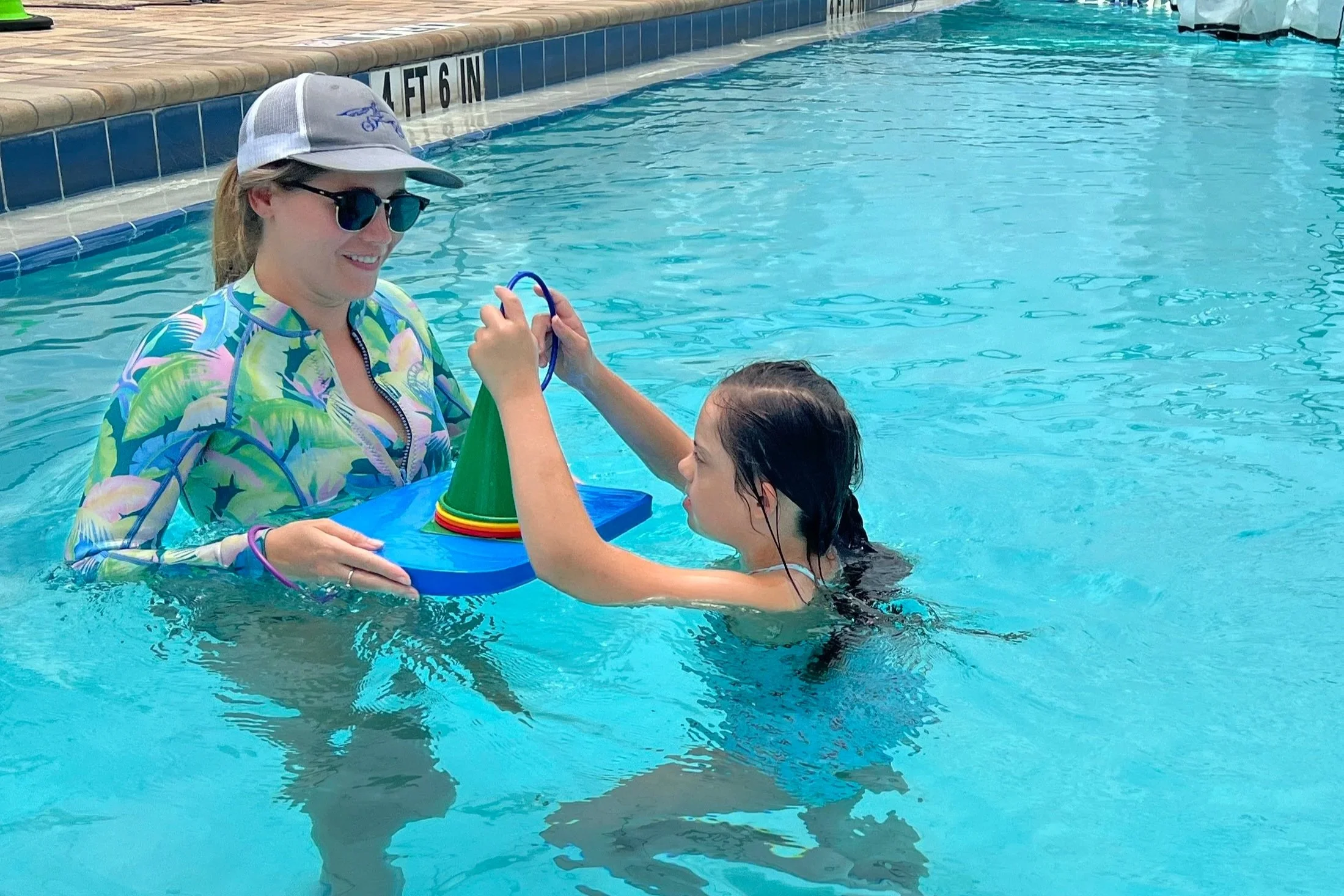 Child participating in pediatric aquatic therapy with an occupational therapist in the pool at Apollo Beach Therapy Center.