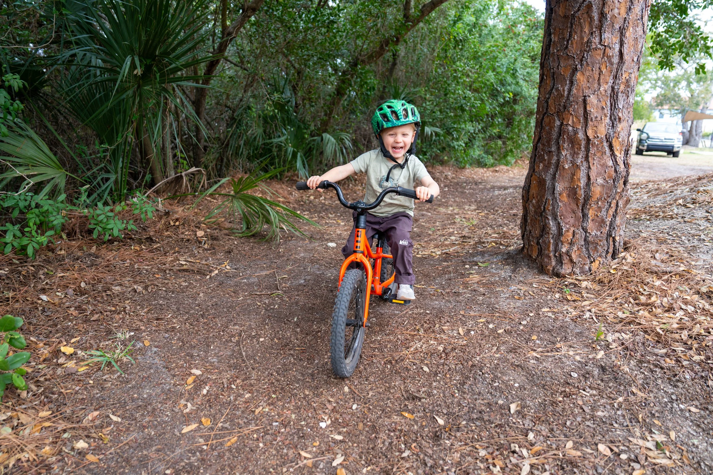 Child practicing balance and coordination while riding a bike during occupational therapy at Apollo Beach Therapy Center.