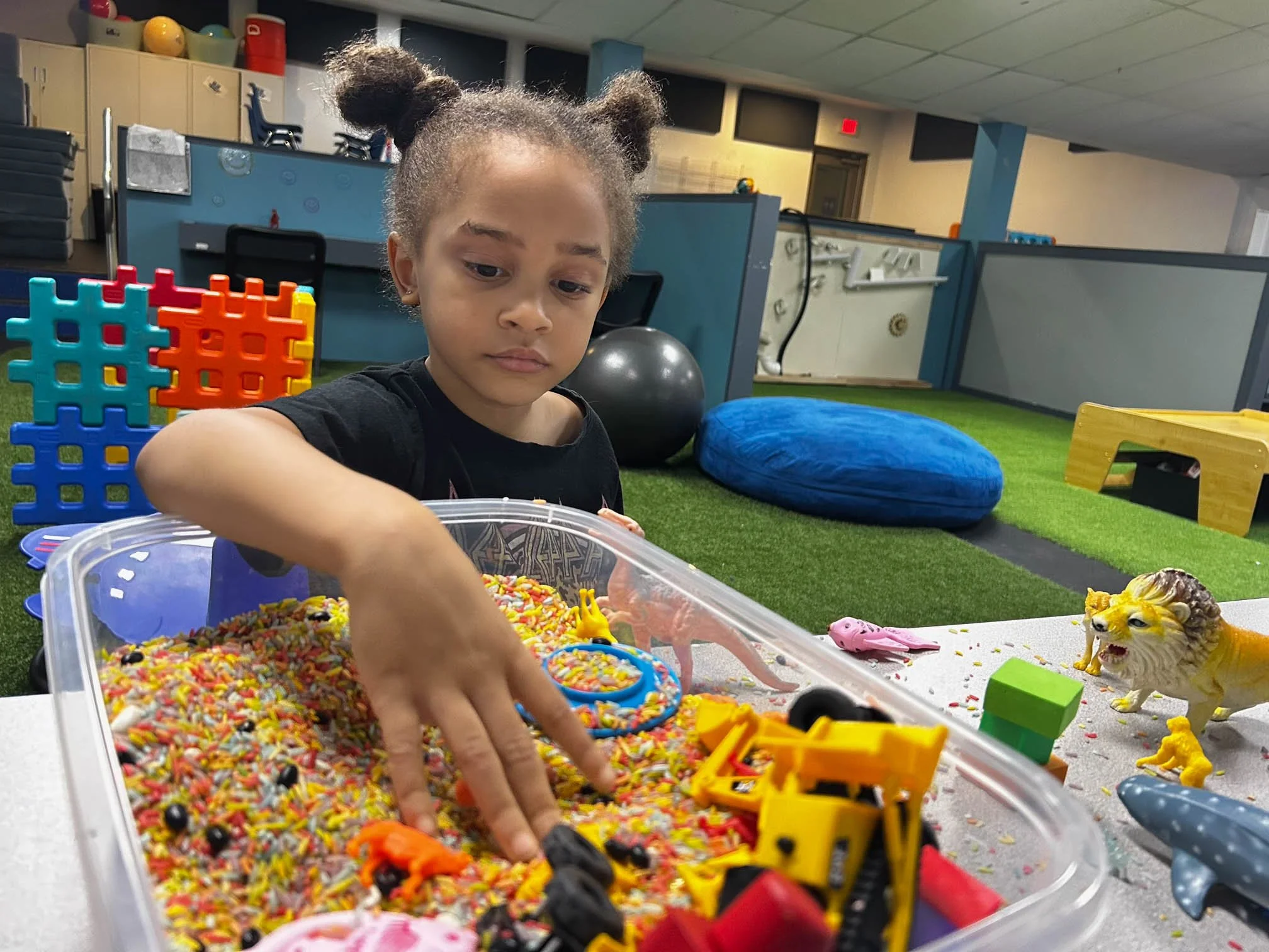 Child exploring a tactile sensory bin during pediatric occupational therapy at Apollo Beach Therapy Center.