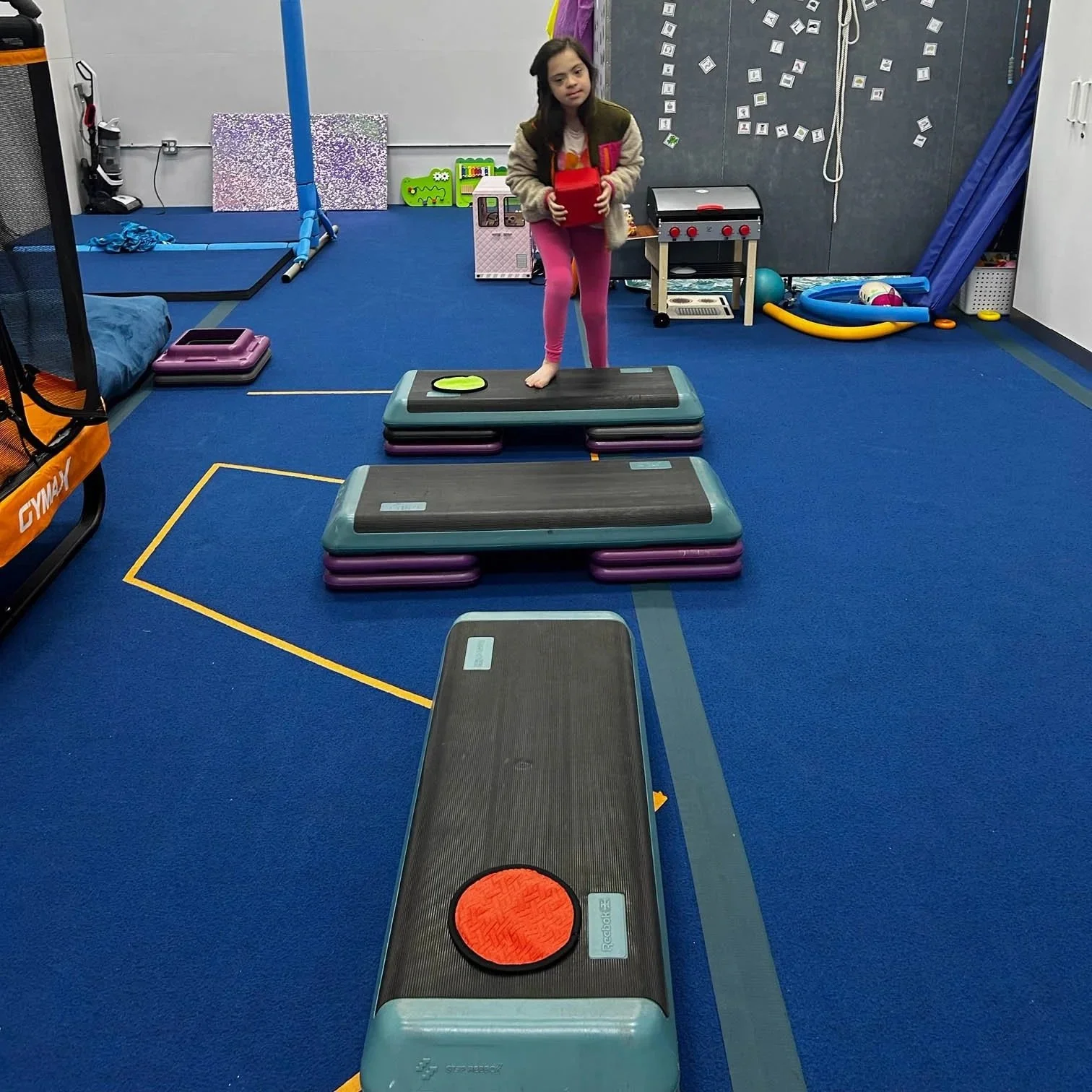 Child completing an indoor obstacle course to address balance, coordination, and motor planning during occupational therapy.