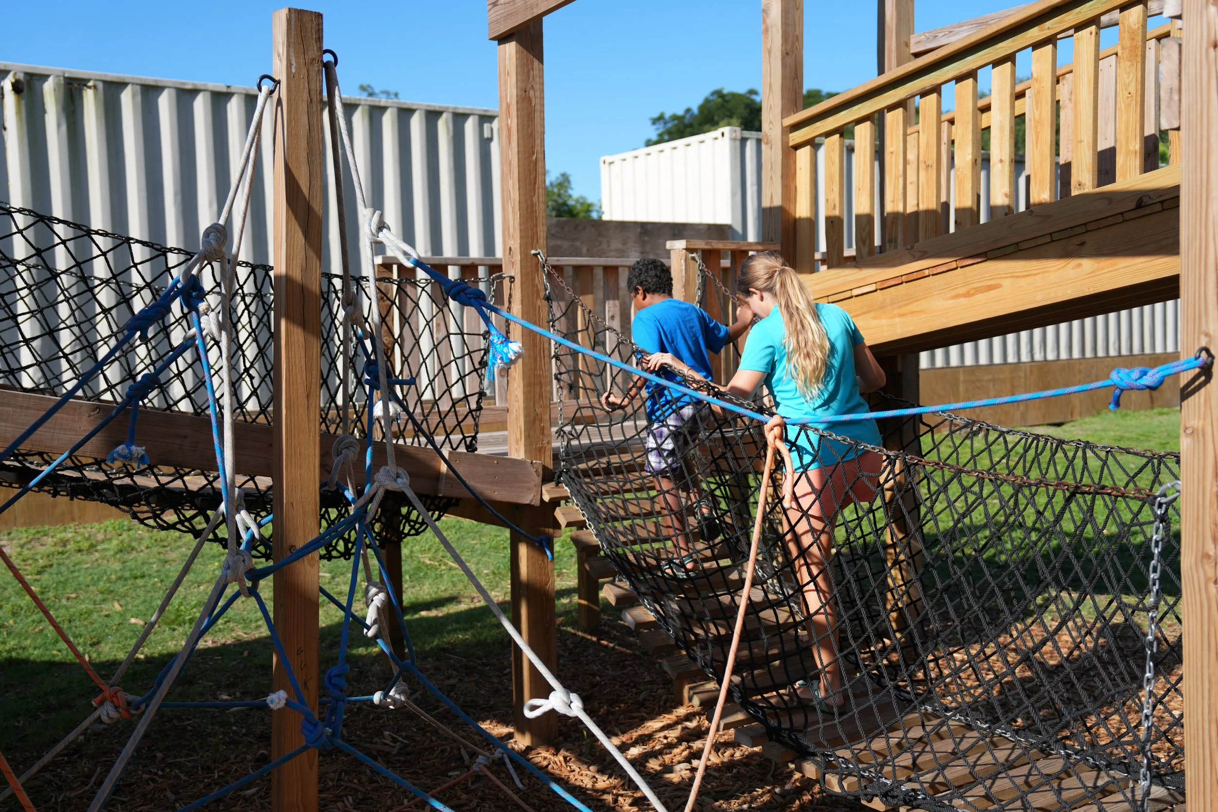 Child navigating playground equipment with therapist support during outdoor occupational therapy at Apollo Beach Therapy Center.