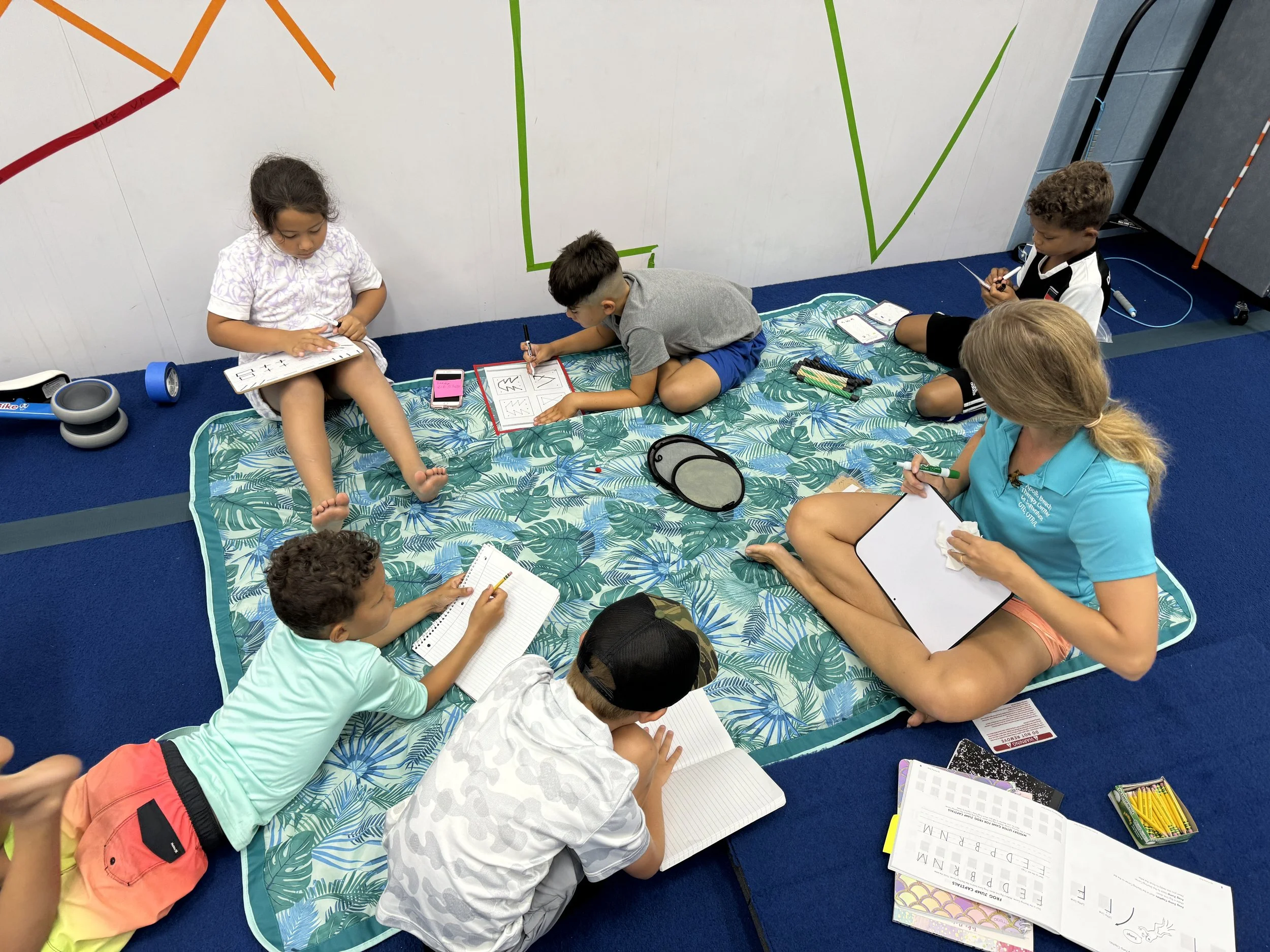 Children participating in a therapist-led handwriting and social participation group at Apollo Beach Therapy Center.