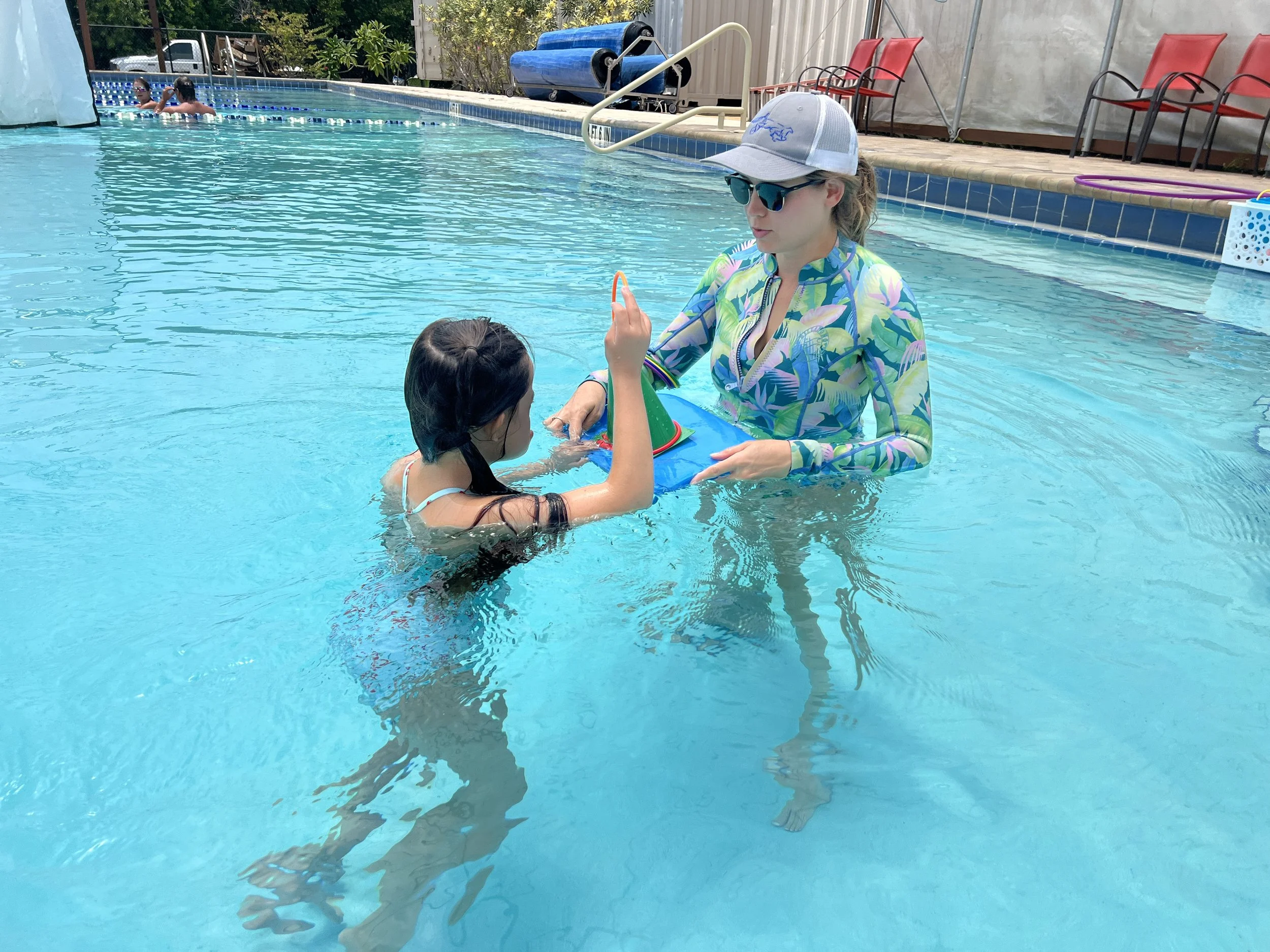 Child engaging with an occupational therapist during an aquatic therapy activity at Apollo Beach Therapy Center.