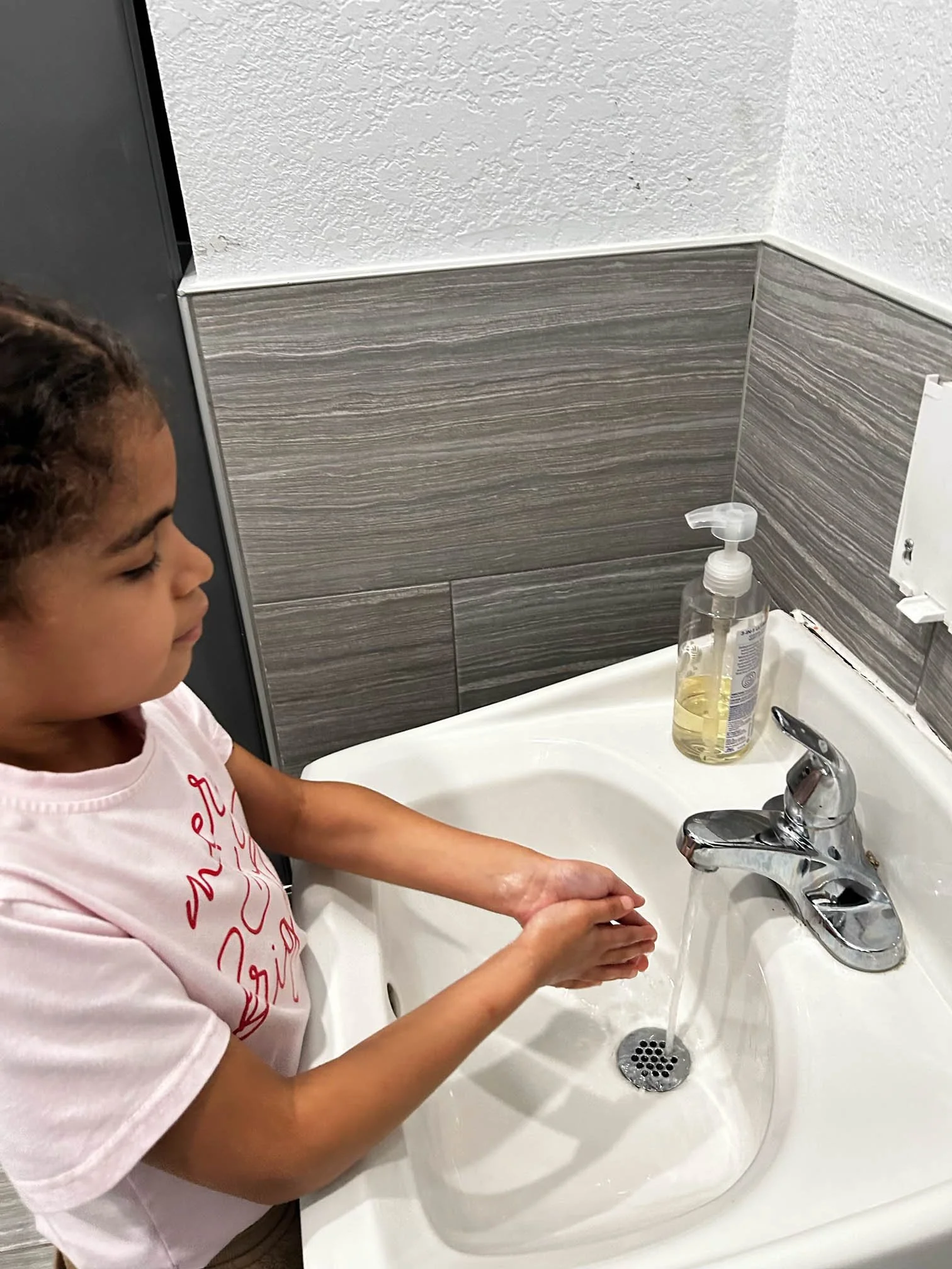 Child practicing handwashing as part of daily living skills during pediatric occupational therapy.
