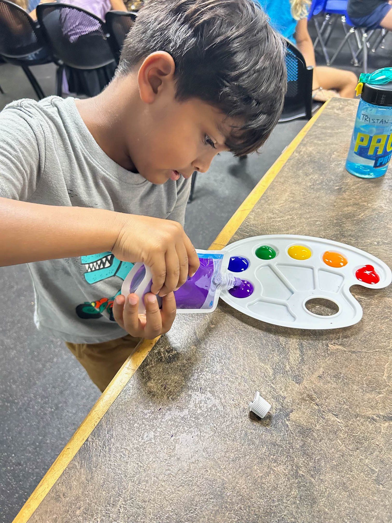 Child using small tools during a fine motor occupational therapy activity at Apollo Beach Therapy Center.