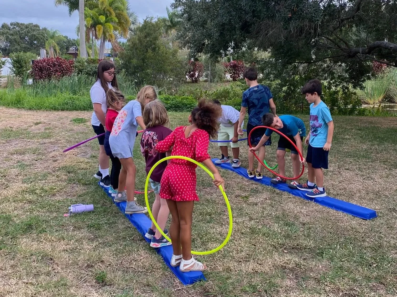 Children participating in an outdoor occupational therapy activity addressing balance, coordination, motor planning, and peer participation at Apollo Beach Therapy Center.