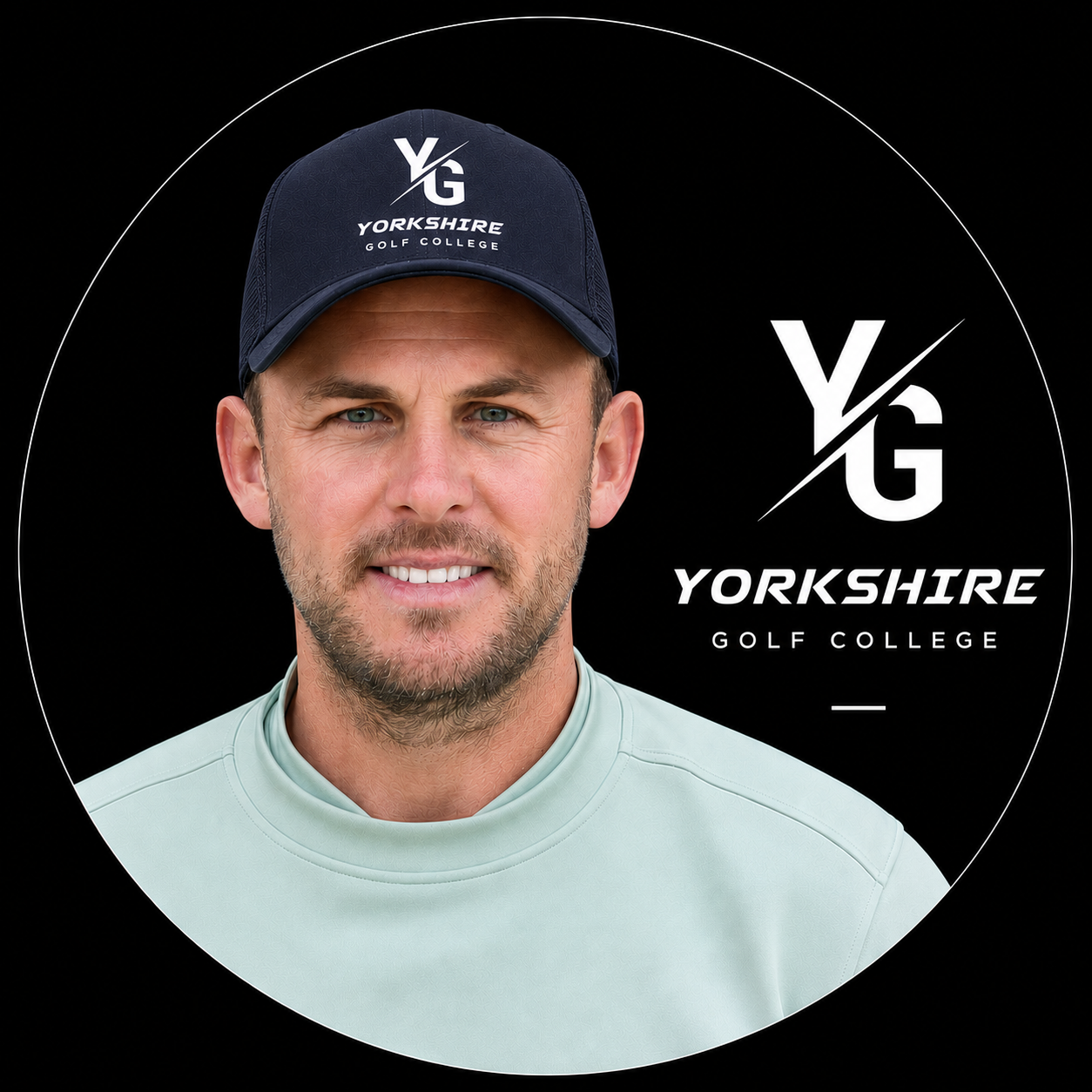 A man wearing a blue hat with the golf show logo, smiling, with a black background featuring the Yorkshire Golf Academy logo and text.