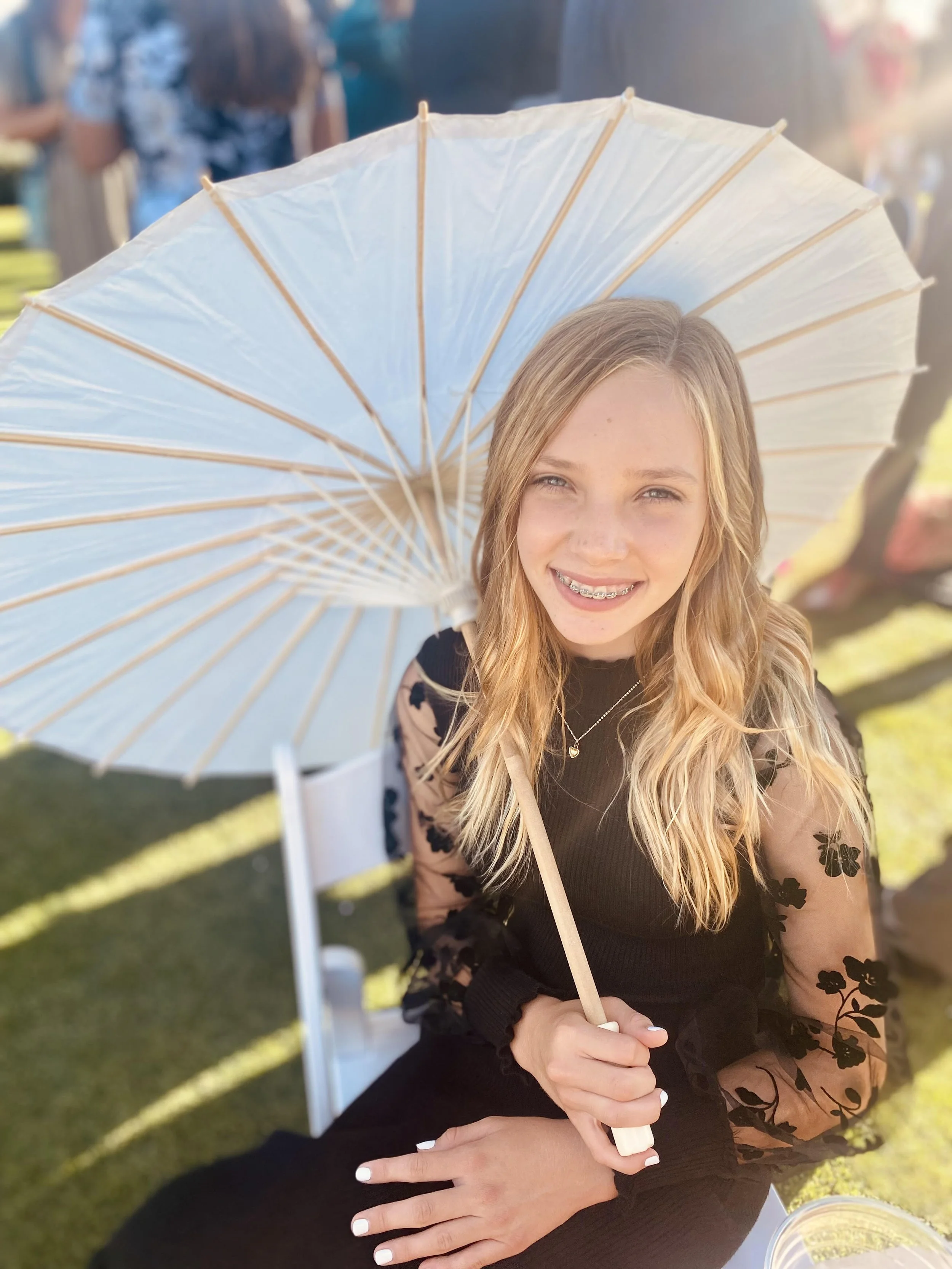 Young girl with braces holding a white parasol