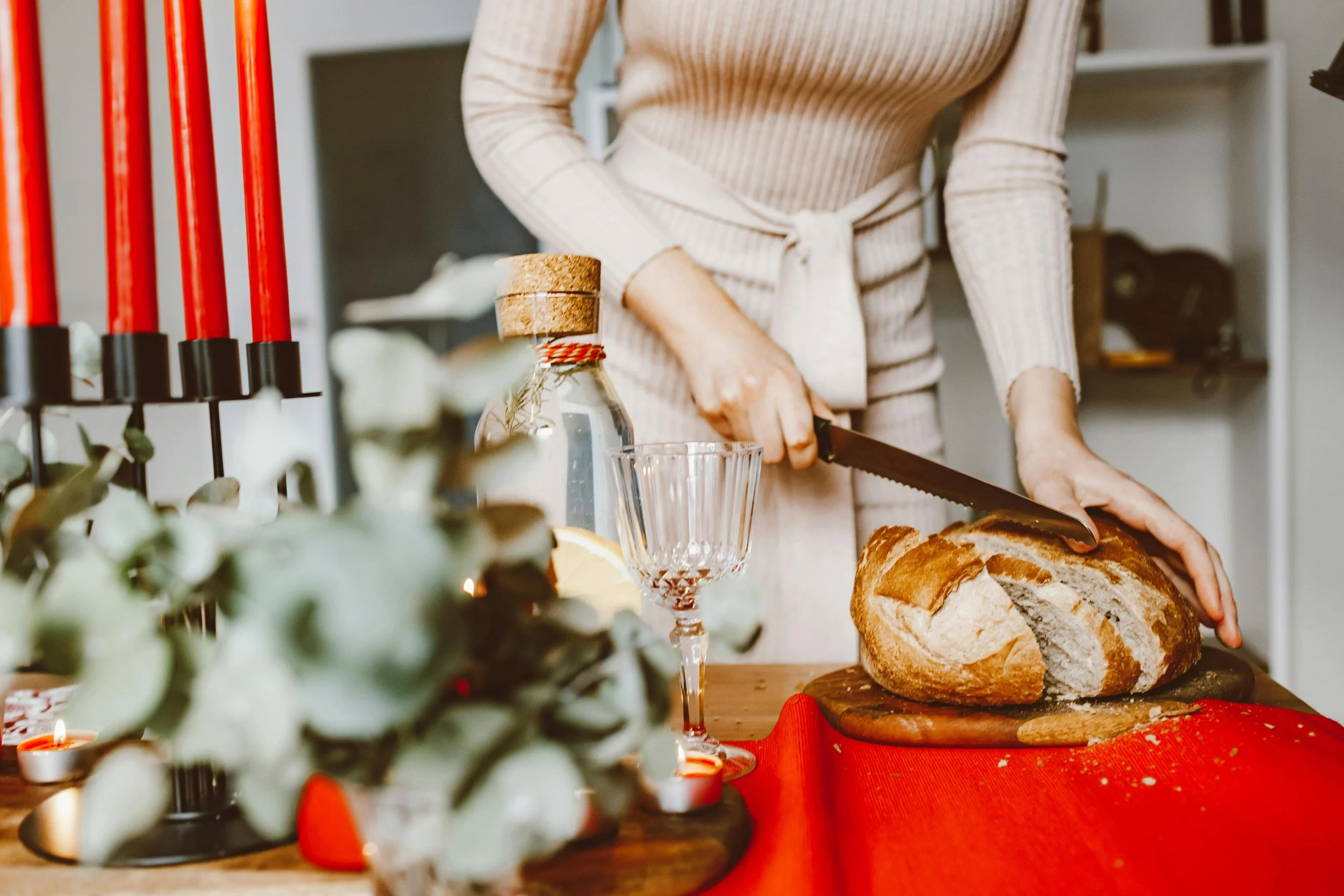 Woman cutting her bread on a wooden cutting board
