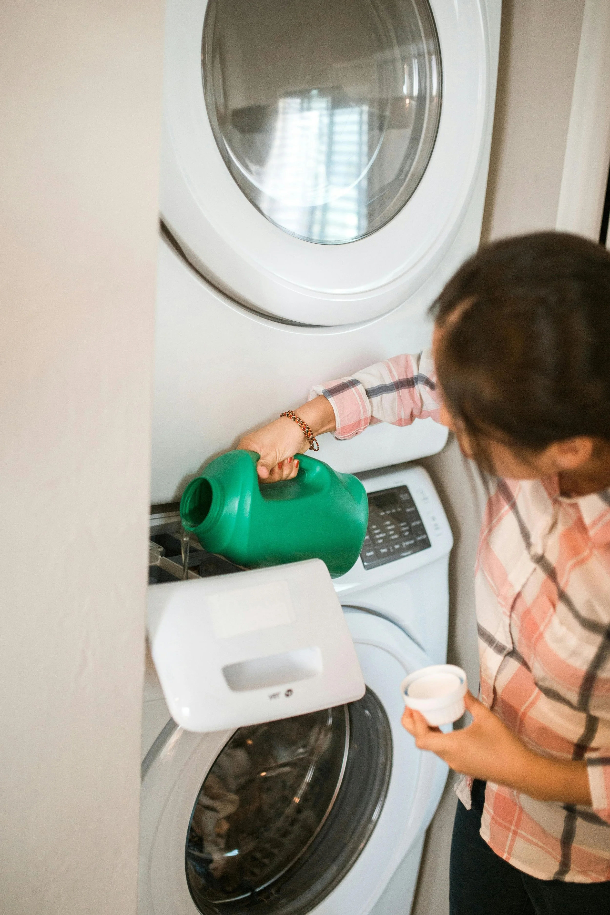 A woman pouring detergent in the washing machine