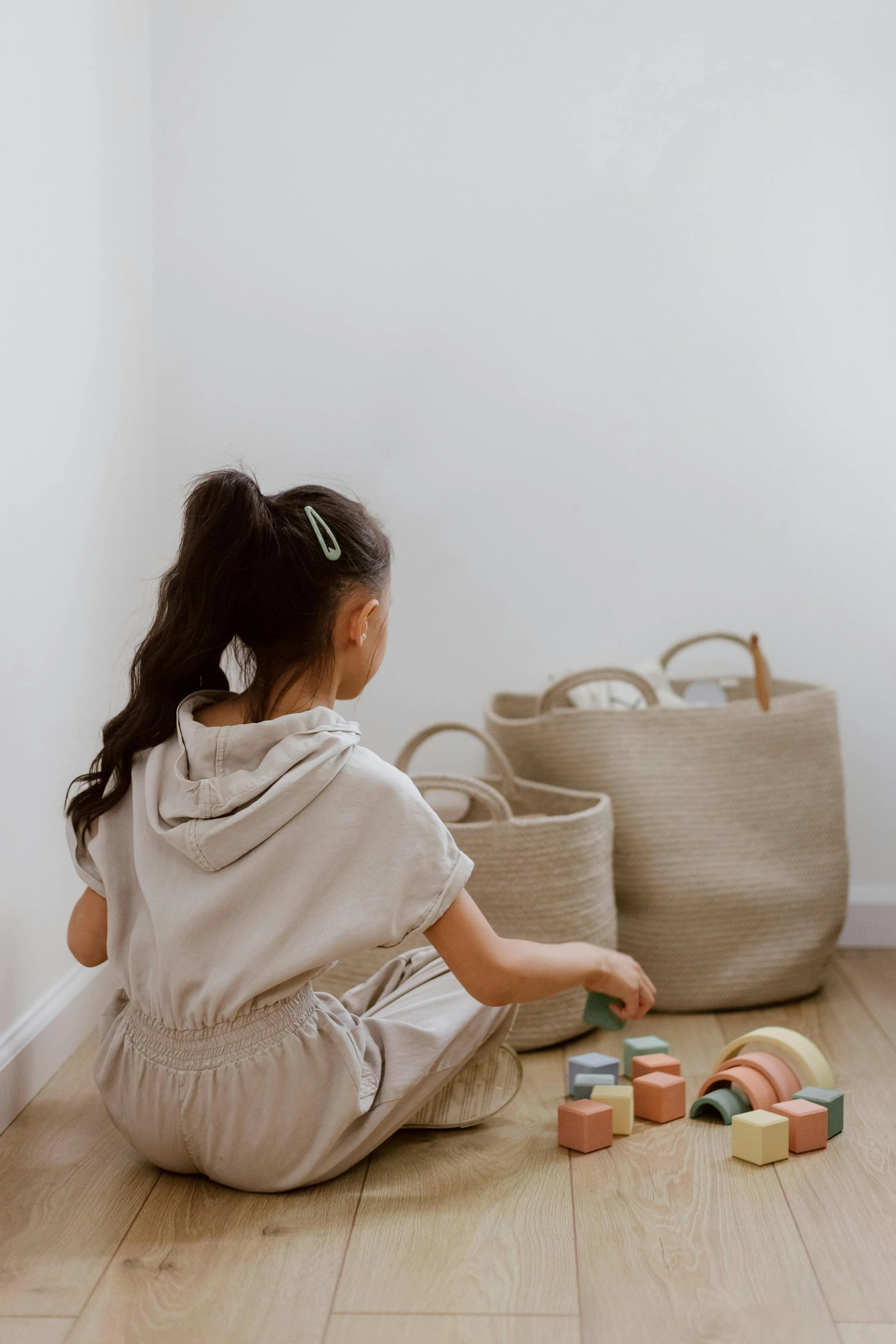 A young girl putting her toys away