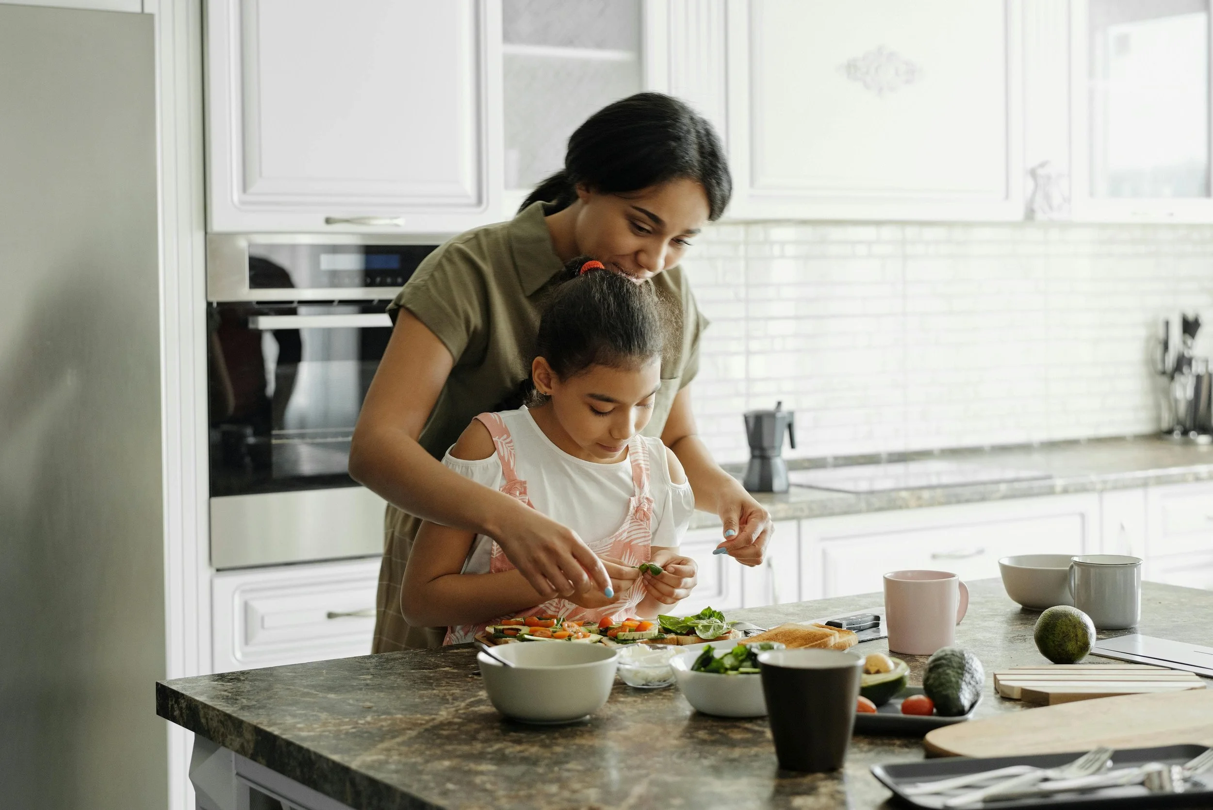 Mother and daughter cooking together in the kitchen
