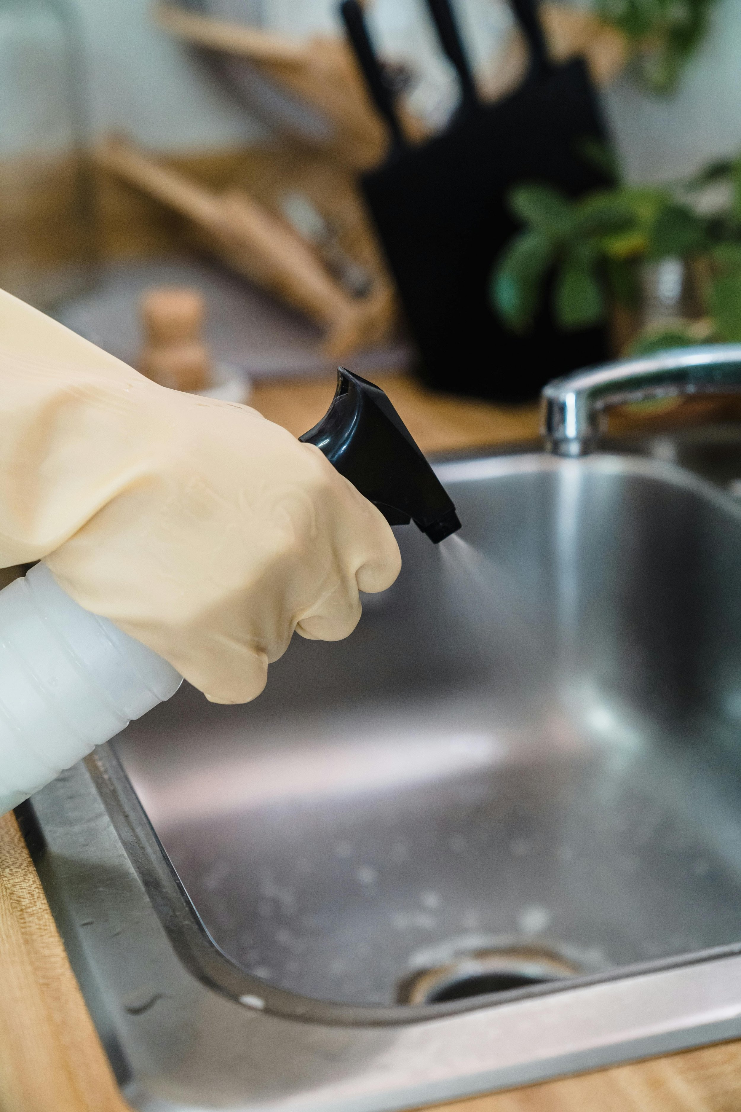 Woman spraying the sink with cleaner